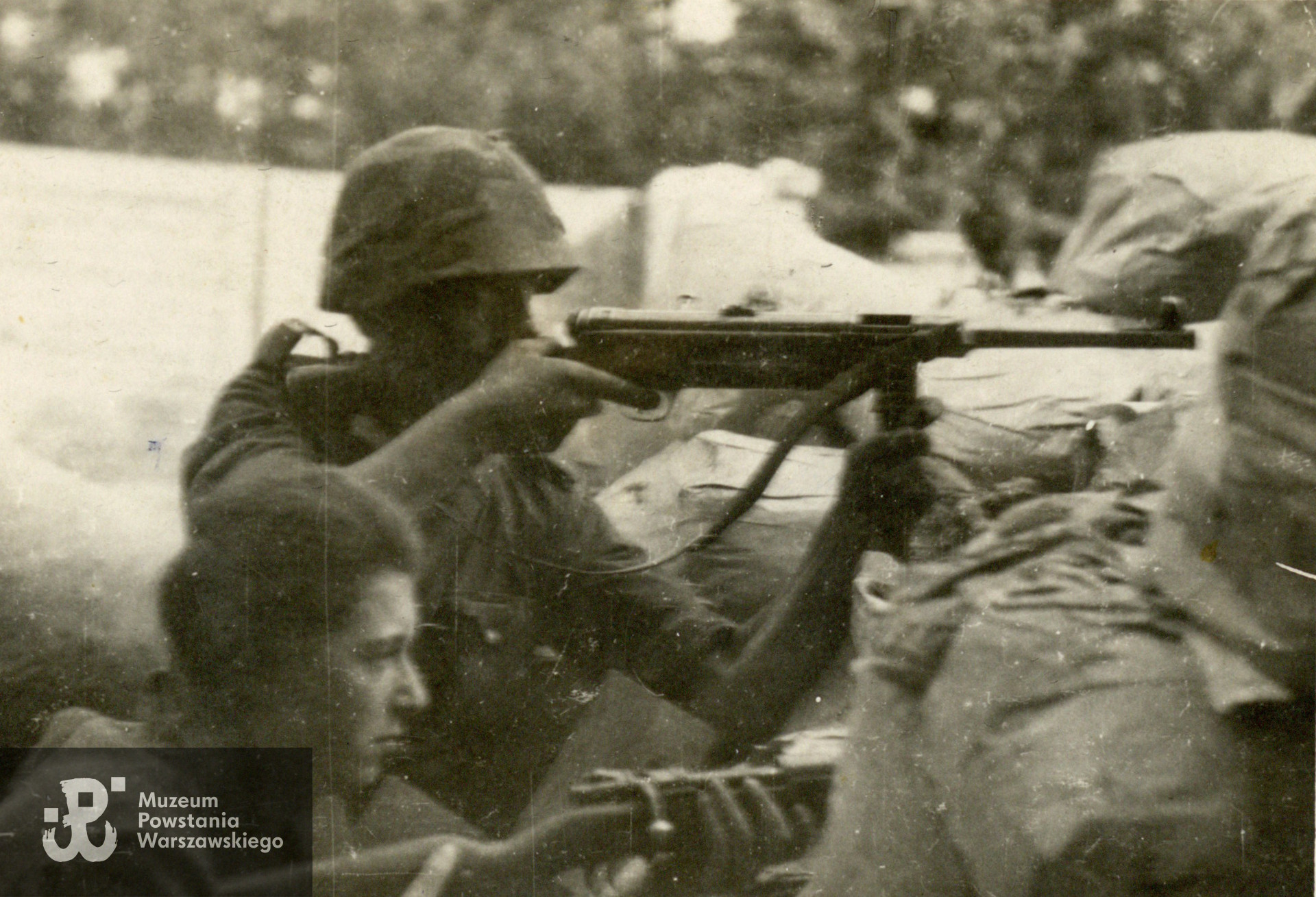 Fotografia  z okresu Powstania Warszawskiego pochodząca ze spuścizny po Adamie Zbigniewie Domańskim ps. Zbyszek. Śródmieście Południe, róg ul. Piusa XI (Pięknej) i Alej Ujazdowskich. Na zdjęciu żołnierze ze zgrupowania "Ruczaj" z kompanii "Habdank": łączniczka "Basia" - Barbara Mączyńska i strz. NN. Fotografia pochodzi ze spuścizny po Adamie Zbigniewie Domańskim, udostępniła p. Zofia Elżbieta Grzebalska z d. Domańska, córka Powstańca. Skany wykonano w Muzeum Powstania Warszawskiego w lutym 2024 r. 