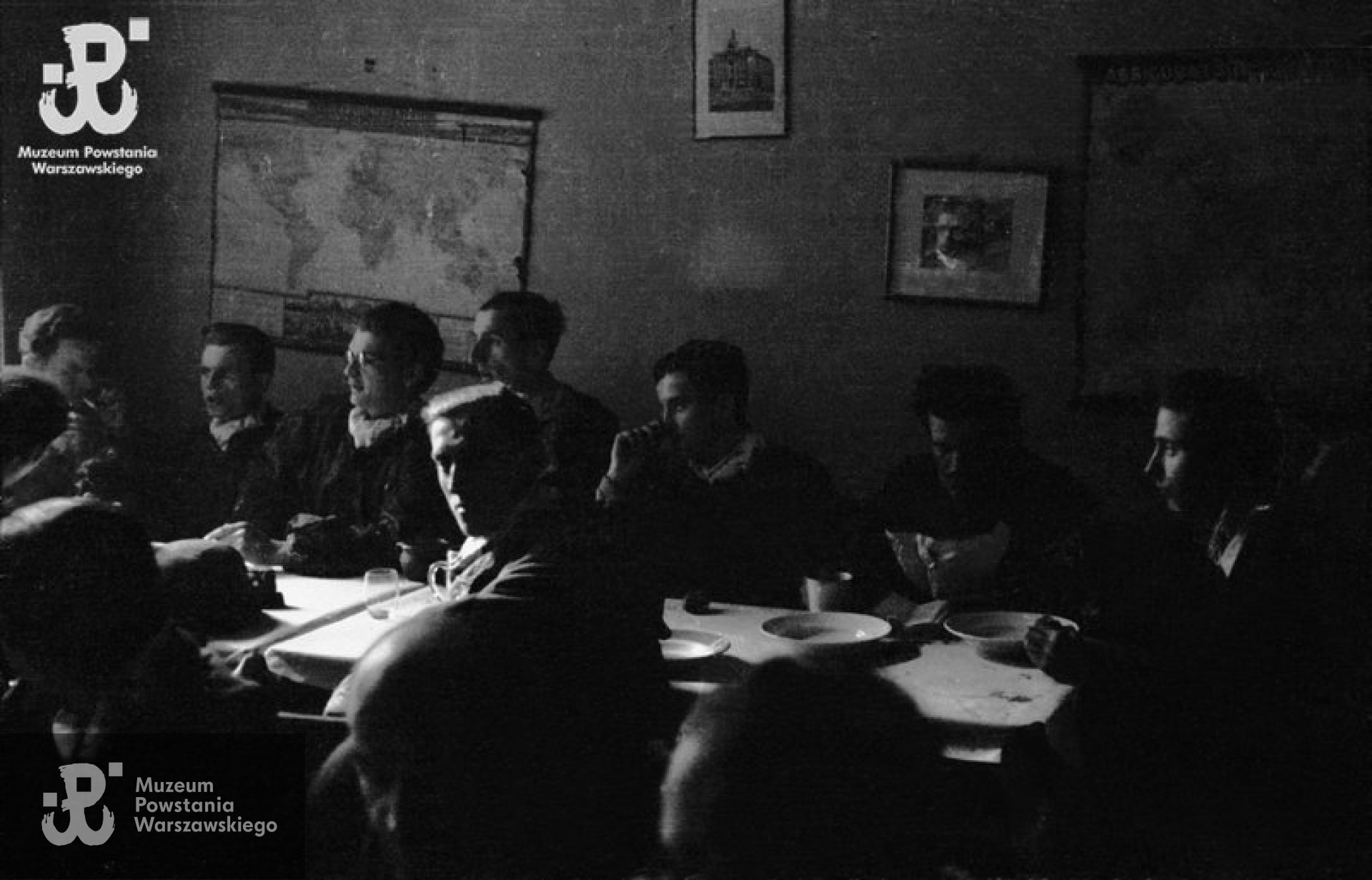 Fotografia z Powstania Warszawskiego. Śródmieście Północne, druga połowa września 1944. Posiłek żołnierzy z kompanii „Anna” Batalionu „Gustaw” w kwaterze przy ulicy Jasnej 19. Przy ścianie siedzą od lewej: NN, kpr. Tadeusz Przybyłowski „Roma” , st. strz. Wiesław de Fournier „Renard” , strz. Zygmunt Łyczkowski „Łęczyc” , kpr. Jerzy Sikorski „Sixton”. Po drugiej stronie stołu, zwrócony twarzą do fotografującego, st. strz. Jerzy Łyczkowski „Łan”. Autorem zdjęcia jest Wiesław Chrzanowski „Wiesław”. Fot. ze zbiorów Muzeum Powstania Warszawskiego, sygn. MPW-IN/3323