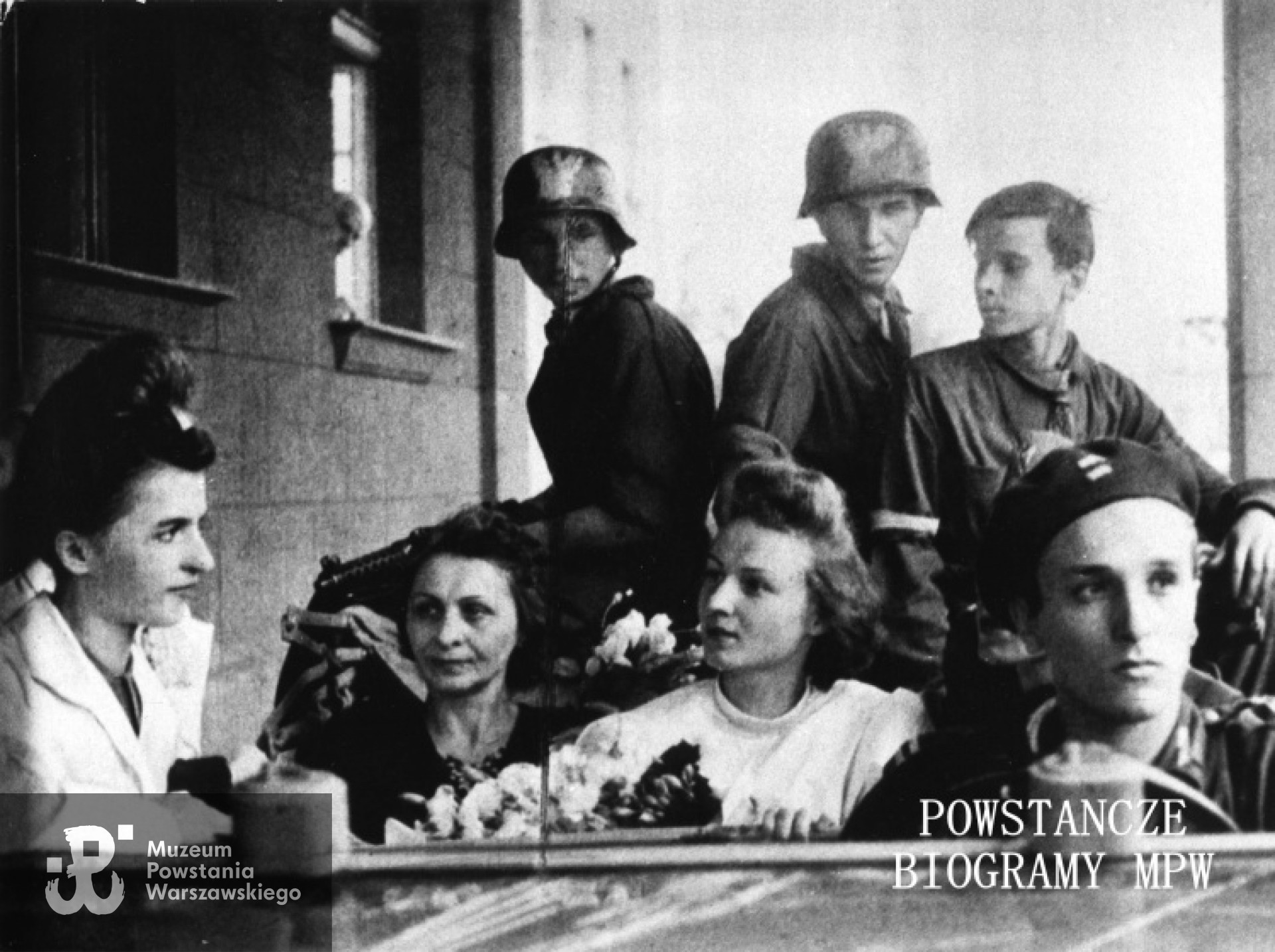 Zdjęcie autorstwa Sabiny Żdżarskiej "Anna": Powstanie Warszawskie. Fotografia z Powstania Warszawskiego. Nowożeńcy wraz z kolegami w zdobycznym samochodzie przy wejściu do szpitala sióstr elżbietanek przy ulicy Goszczyńskiego. Ze zbiorów Muzeum Powstania Warszawskiego, sygn. MPW-IK/1710