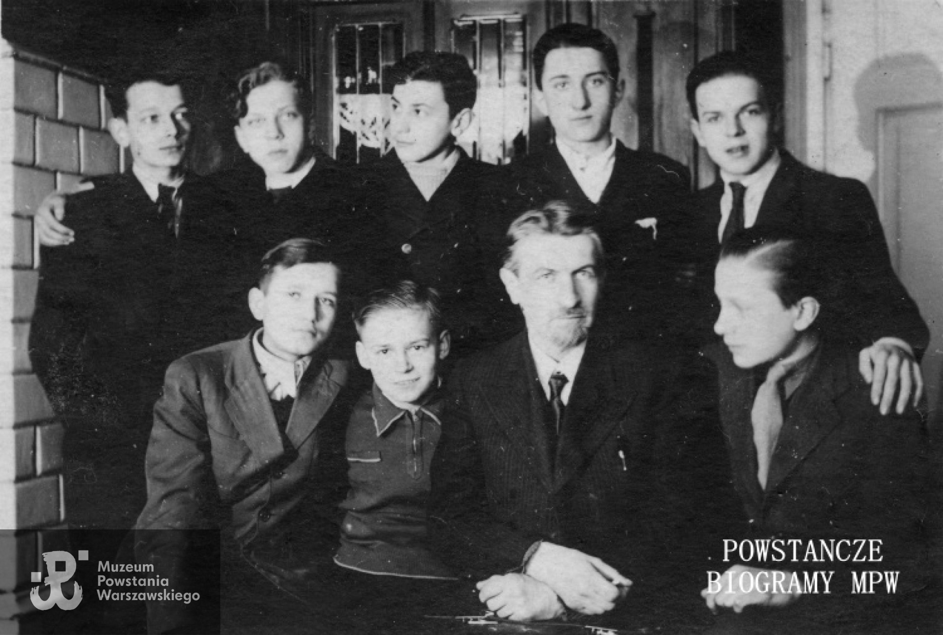 Fotografia z okresu okupacji niemieckiej - 1940 - 1941. Tajne komplety w mieszkaniu Wacława Czyża.Stoją od lewej: Tadeusz Gronek, NN, Zadrożny, Leszek Kołodziejczyk, Wacław Czyż. Siedzą od lewej: Tadeusz Blejarski, Stefan Bilski, Erazm Samotycha (prof.), Zdzisław Pawłowski. MPW-IP/5245