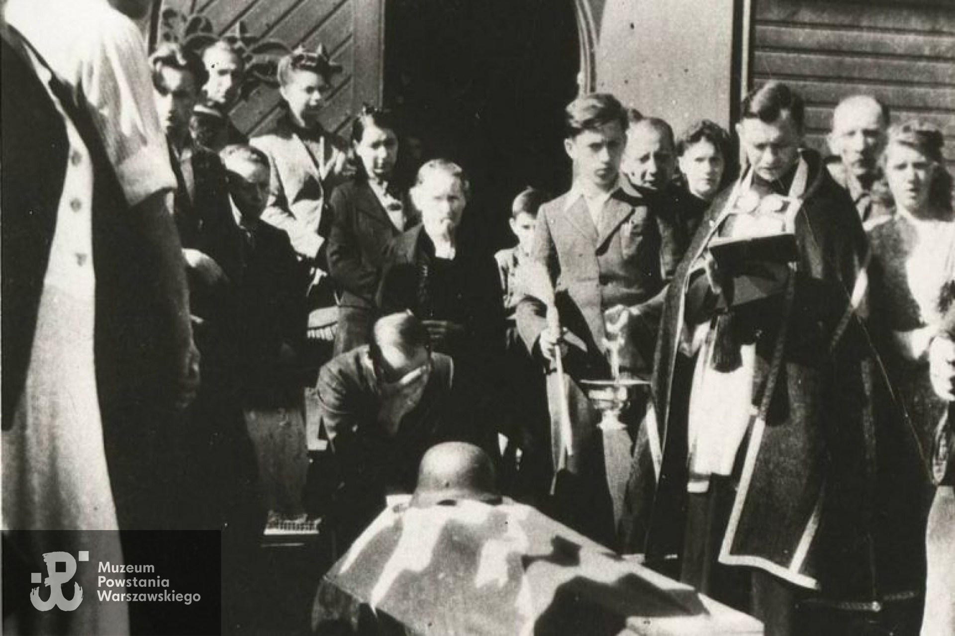 Ksiądz Wacław Szelenbaum nad trumną Sławka Klejmenta przed kościołem parafialnym w Legionowie, 5 sierpnia 1944 roku.  Fot. ze zbiorów Muzeum Historycznego w Legionowie, źródło: Gazeta Powiatowa, <i>Nasza Historia: Powstanie Warszawskie w Legionowie.</i> 2021.