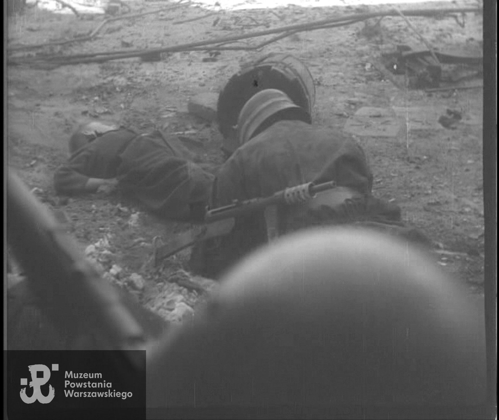 Kadr z Powstańczej Kroniki Filmowej - wyciąganie spod niemieckiego ognia ciała zastrzelonego przez snajpera łącznika "Orła Białego". Powstańcem wyciągającym chłopca jest Mieczysław Mirecki "Błyskawica"