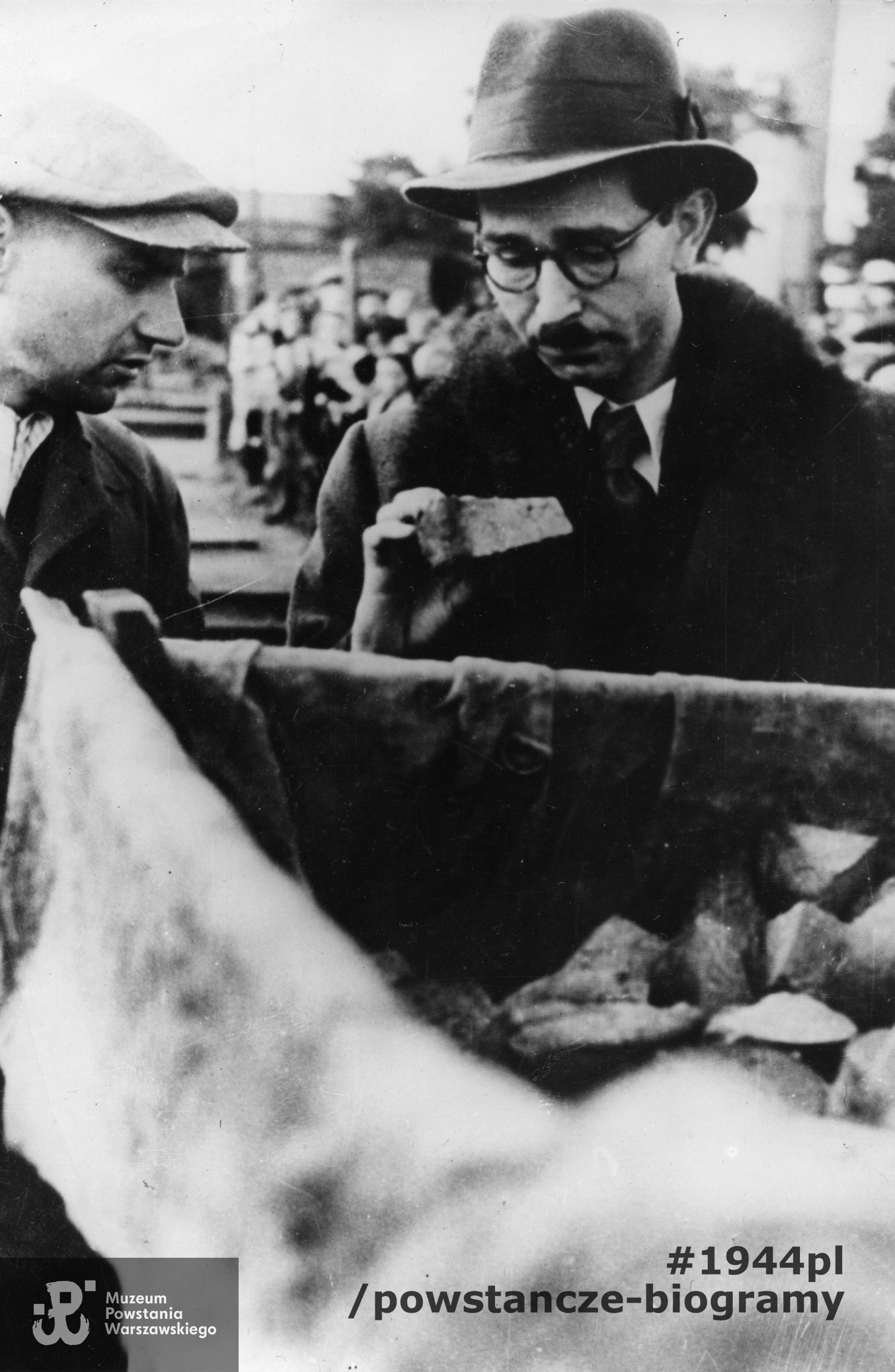 Fotografia z okresu Powstania Warszawskiego wykonana 29 września 1944 w obozie przejściowym dla ludności cywilnej w Pruszkowie (Dulag 121). Dr Hieronim Bartoszewski z Polskiego Czerwonego Krzyża nadzorujący akcję rozdawania chleba,  Autor zdjęcia nieznany. Fot. ze zbiorów Muzeum Powstania Warszawskiego, sygn. MPW-IP/8655