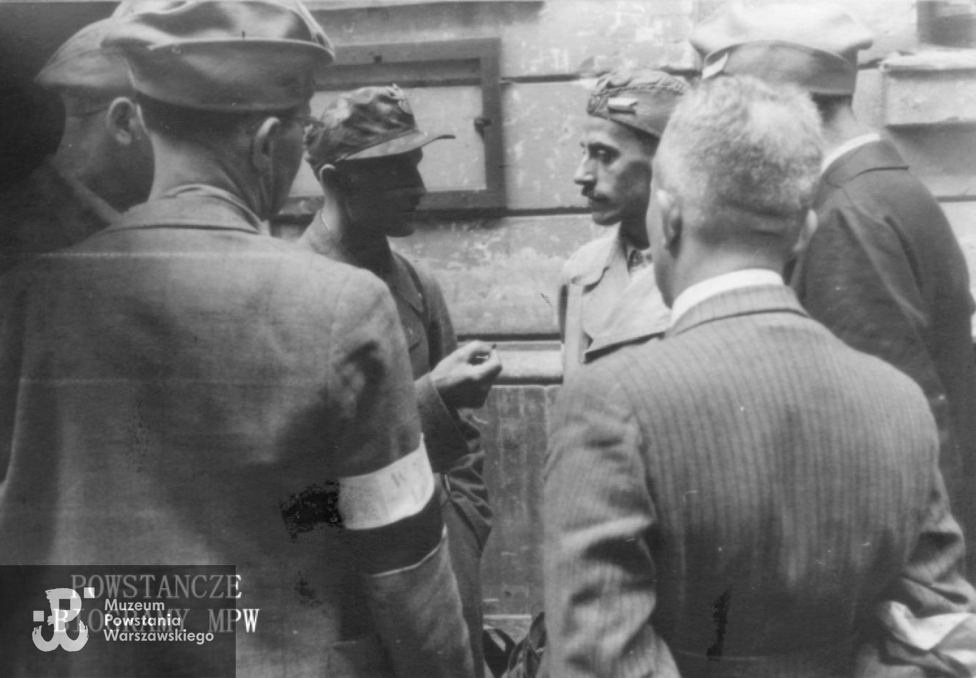 Fotografia z Powstania Warszawskiego. Śródmieście Północne. Podwórze kamienicy przy ul. Marszałkowskiej 125, gdzie mieściła się kwatera sztabu IV Rejonu Obwodu Śródmieście mjr. "Zagończyka". Podinspektor WSOP - ppor. inż. Tadeusz Sztalkop  "Zarzycki", "Kazimierz" (trzeci od prawej, w jasnej bluzie i furażerce) odbiera meldunek. Fot. autorstwa Zygmunta Kukieły ps. "Zetka" - ze zbiorów Fototeki MPW, sygn. <a href=" http://www.1944.pl/galerie/fototeka/foto/8278/autor/129"> MPW-IP/2471</a>