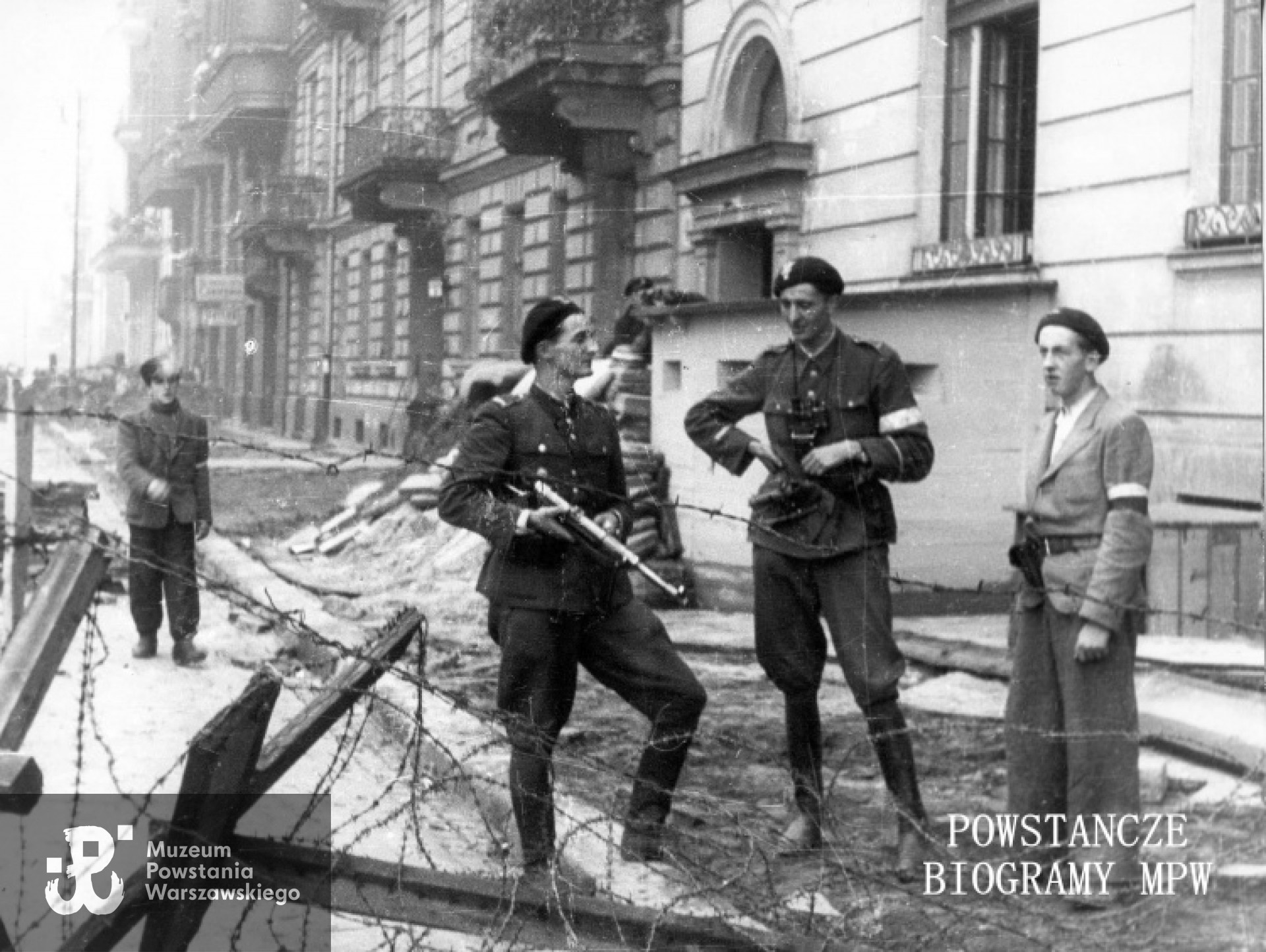 Fotografia  z okresu Powstania Warszawskiego autorstwa Tadeusza Bonclera: żołnierze batalionu "Golski" u  wylotu Noakowskiego na ul. 6 Sierpnia i Lwowską. Po prawej fragment gmachu gimnazjum Staszica przy Noakowskiego 6, dalej kamienice nr 8, 10 i 12. Ze zbiorów Muzeum Powstania Warszawskiego, sygn. MPW-IK/2541