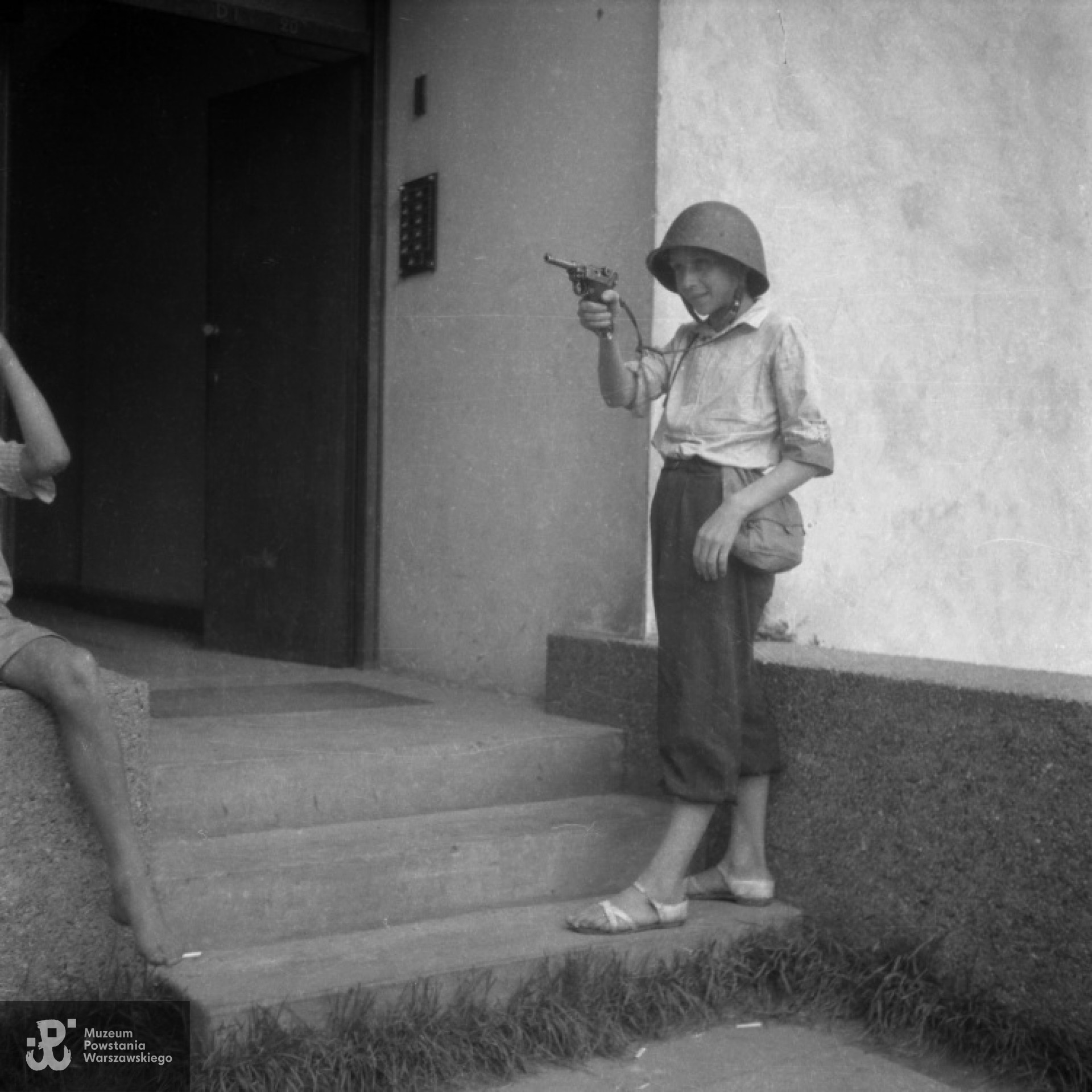 St. strz. Karol Lewandowski "Karolek" ze Zgrupowania "Żniwiarz" na schodach domu przy ulicy Mickiewicza 34. Fot. autorstwa Stefana Lewandowskiego, ze zbiorów fototeki MPW, sygn. MPW-IN/4283. Stefan wykonał <a href="http://www.1944.pl/galerie/fototeka/autor/74"> 39 zdjęć</a>