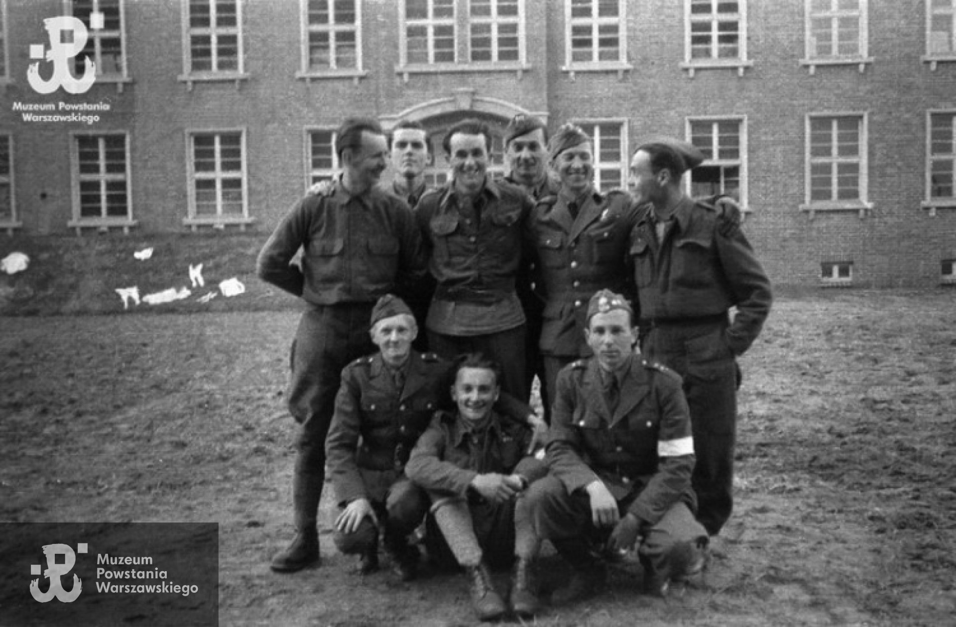 Fotografia z Oflagu X C w Lubece. Grupa polskich oficerów na placu przed blokiem koszarowym. Od lewej stoją: NN, ppor. Jan Gładych "Bemol" z kompanii "Harcerskiej" batalionu "Gustaw", ppor. cc Zygmunt Ulm "Szybki" - oficer ordynansowy dowództwa zgrupowania "Róg", NN, kpt. Alfred Pokultinis "Fon" - dowódca łączności Grupy "Północ", NN. Siedzą od lewej: ppor. Tadeusz Fijewski "Kostek", ppor. Stefan Mączyński "Szczepcio" z kompanii "Harcerskiej" batalionu "Gustaw", NN