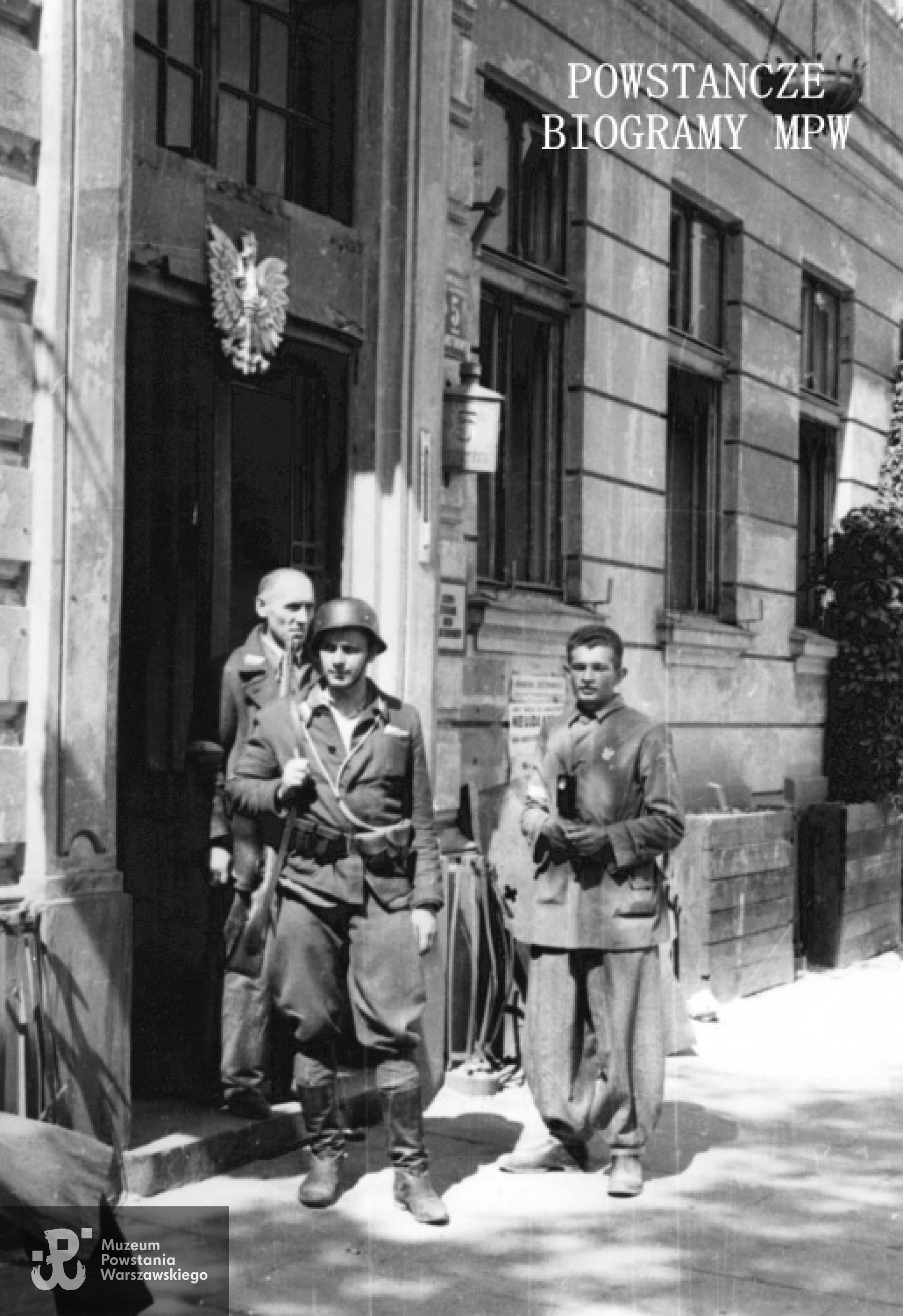 Fotografia z Powstania Warszawskiego autorstwa Eugeniusza Lokajskiego. Śródmieście Północne. Grupa powstańców stojących przy wejściu do kamienicy przy placu Dąbrowskiego 5, na murze widoczny propagandowy afisz powstańczy: "Nie ujdą kary". Po prawej Zygmunt Soczek "Ładoń". Ze zbiorów Fototeki MPW, sygn. <a href=" http://www.1944.pl/galerie/fototeka/foto/387/kategoria/95"> MPW-IN/262</a>