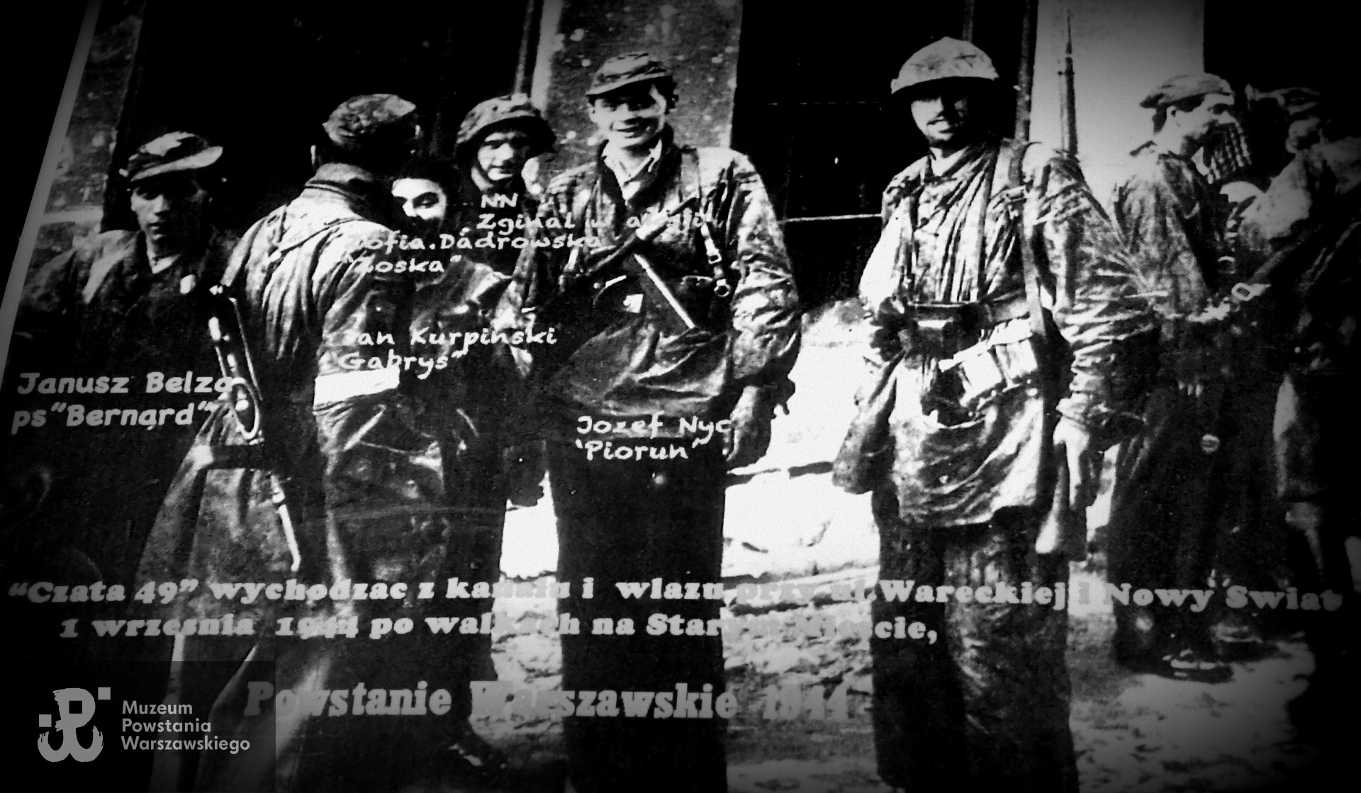 Powstańcy na ul. Wareckiej - tu według opisu pierwszym żołnierzem z lewej jest p. Janusz Bełza „Bernard”.  Przedstawiony opis niezweryfikowany przez MPW 