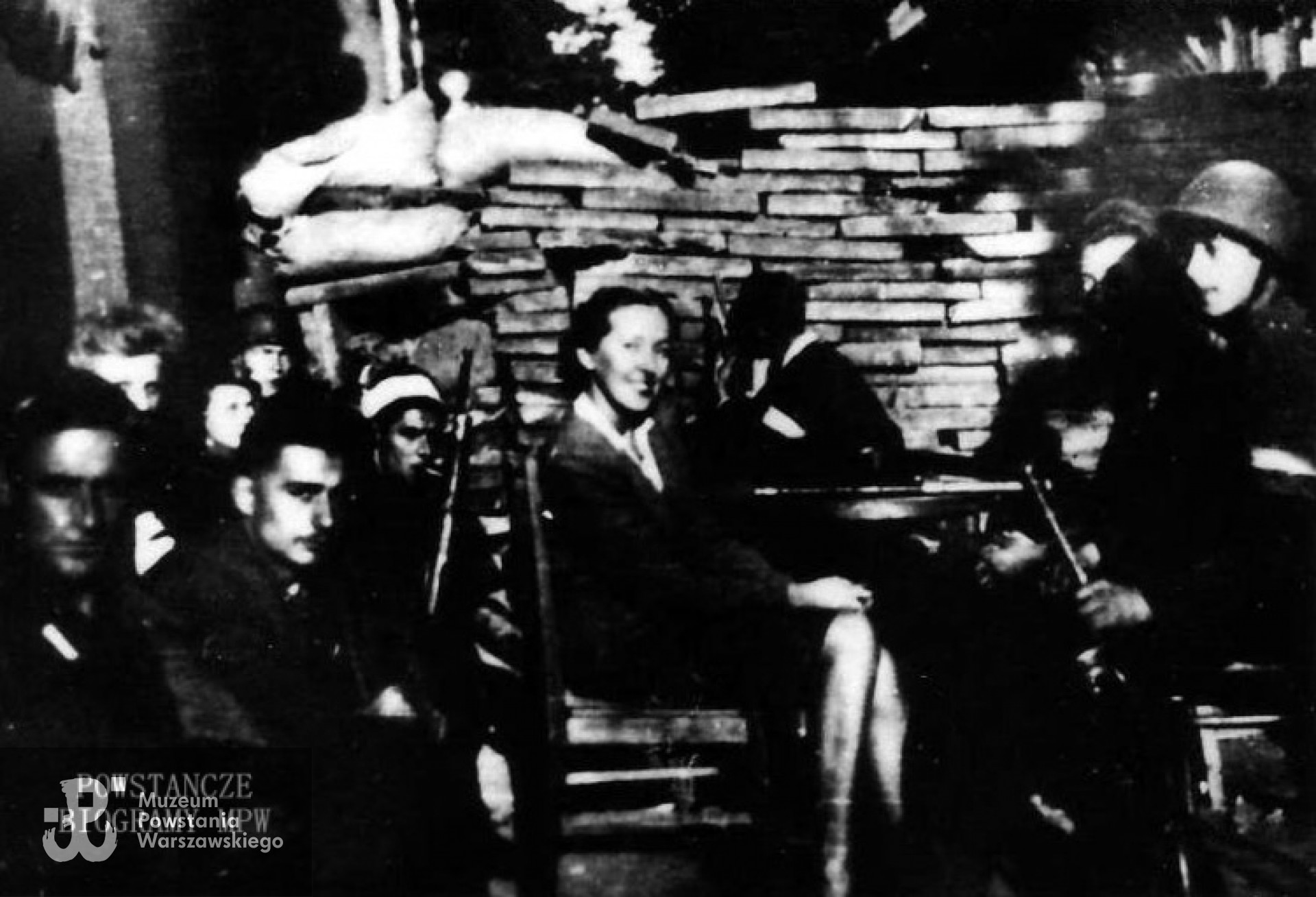 Powstanie Warszawskie - żołnierze batalionu "Ruczaj" przy barykadzie. Andrzej Krauss siedzi po lewej,  z bandażem na głowie. Fot. z archiwum rodzinnego Katarzyny Krauss