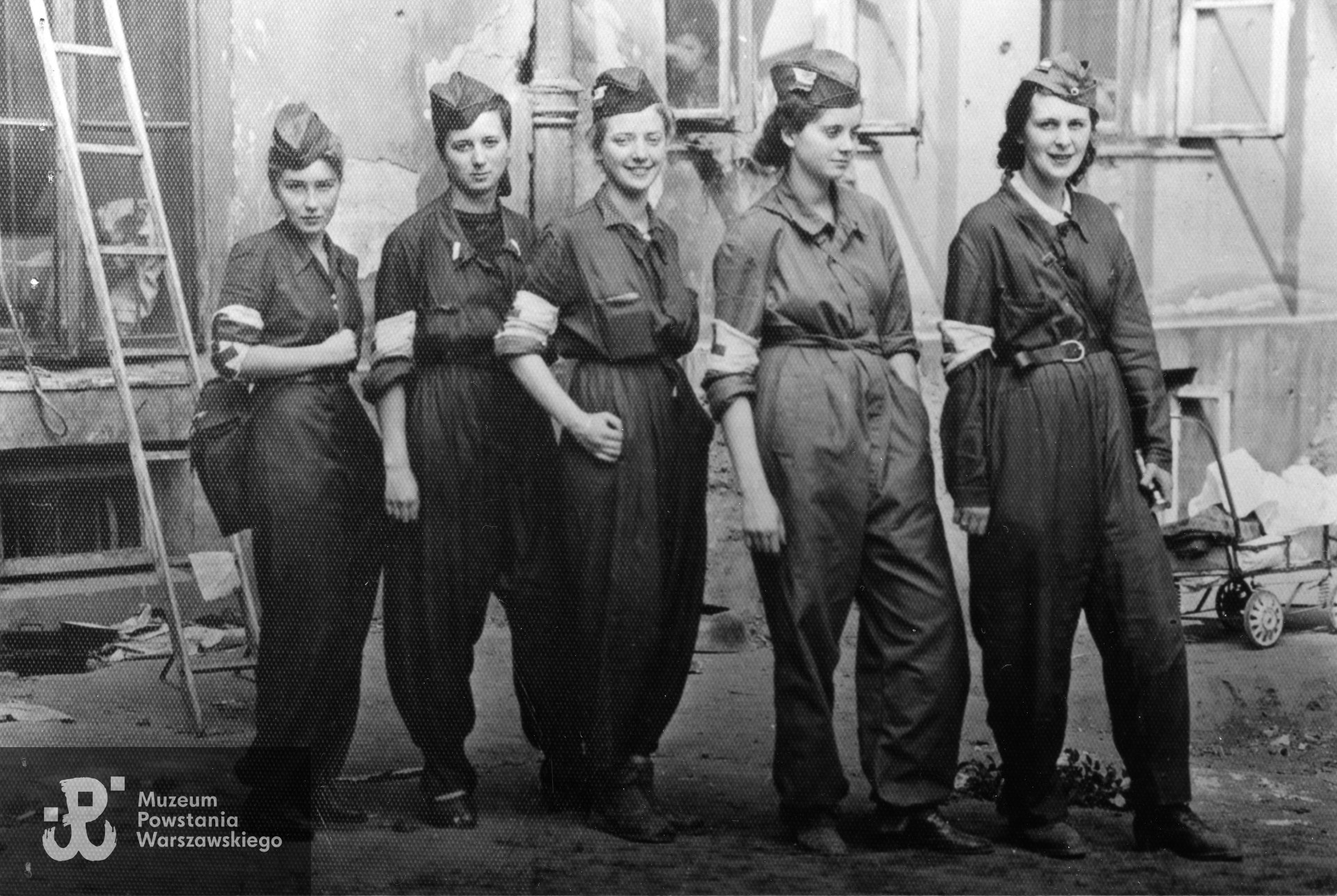 Fotografia z Powstania Warszawskiego przedstawiająca sanitariuszki 3  kompanii batalionu "Bełt".  Stoją od lewej: Barbara Przygodzka "Żabka", Alina Kłopotowska " Pantera", Izabela Sztos- Zachwatowicz " Ryś", Halina Przybylska " Misia" i Wiera Dudzińska " Angora". Zdjęcie wykonane w dzień po udanej akcji na "Małą PASTę", 22 sierpnia 1944 roku. Fot. ze zbiorów Muzeum Powstania Warszawskiego, sygn. MPW-IP/5773, ujęcie tożsame MPW-IP/2081