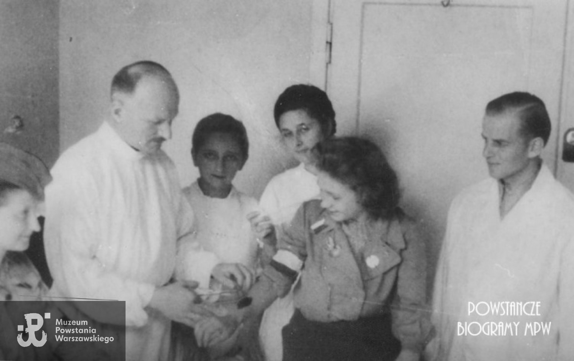 Ta sama fotografia z archiwum Barbary Szeladzińskiej. Powstanie warszawskie. Powiśle, ul. Tamka 30. Doktor Rowiński wyjmuje łączniczce odłamek. Obok doktora Maria Rowińska i Barbara Szuladzińska  "Wanda" (na zdjęciu po lewej).