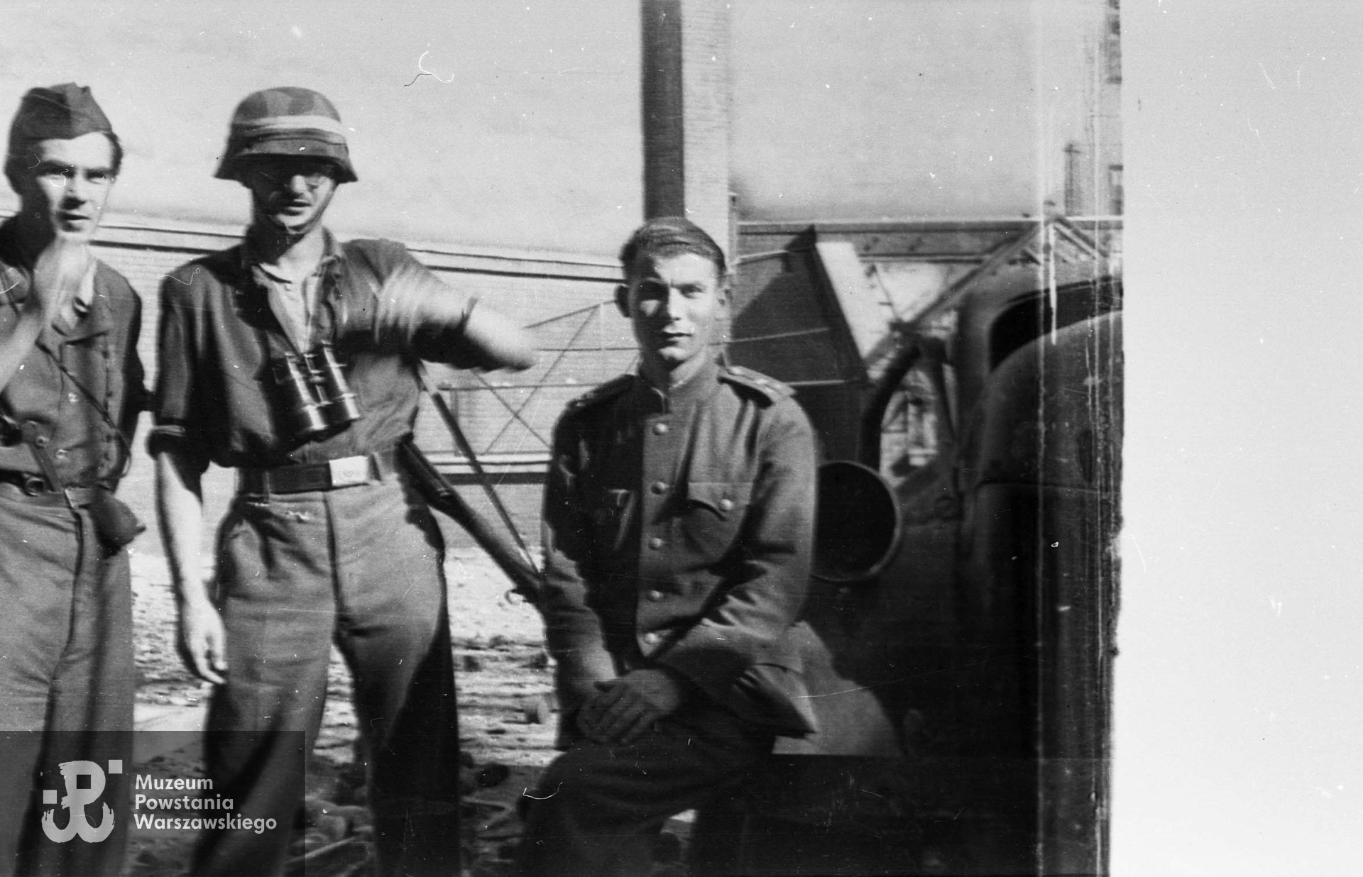 Fotografia z Powstania Warszawskiego autorstwa Mariana Grabskiego ps. Wyrwa, przedstawiająca grupę żołnierzy kompanii "Tadeusz" batalionu "Ruczaj" na dziedzińcu budynku Poselstwa Czechosłowackiego przy ul. Koszykowej 18. W środku stoi ppor. Władysław Zajdler "Żarski" dowódca  plutonu 137, po prawej siedzi rosyjski oficer por. Iwan Jachimow "Wańka". Pierwszy z prawej stoi ppor. Jerzy Janusz Antoniak ps. Miki. Fot. ze zbiorów Muzeum Powstania Warszawskiego, sygn. MPW-IN/1717, ujęcie tożsame MPW-IP/626.

