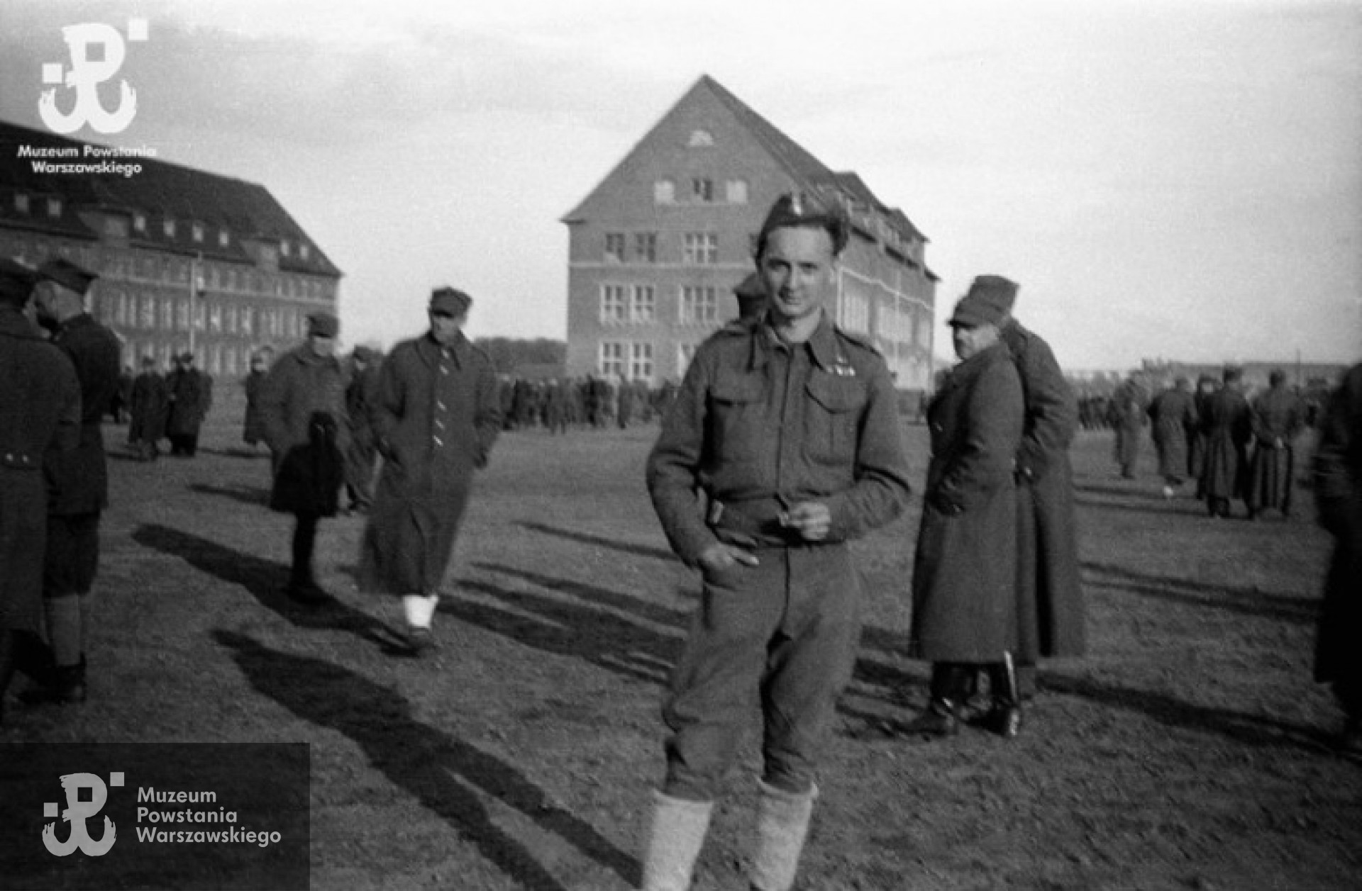 Fotografia z Oflagu X C w Lubece, koniec kwietnia 1945 roku.  Ppor. Stefan Mączyński „Szczepcio” z kompanii harcerskiej Batalionu „Gustaw” po apelu na placu przed blokami koszarowymi. Fot. Wiesław Chrzanowski „Wiesław”, ze zbiorów Fototeki MPW, sygn. <a href=" http://www.1944.pl/galerie/fototeka/foto/3302"> MPW-IN/3402</a>