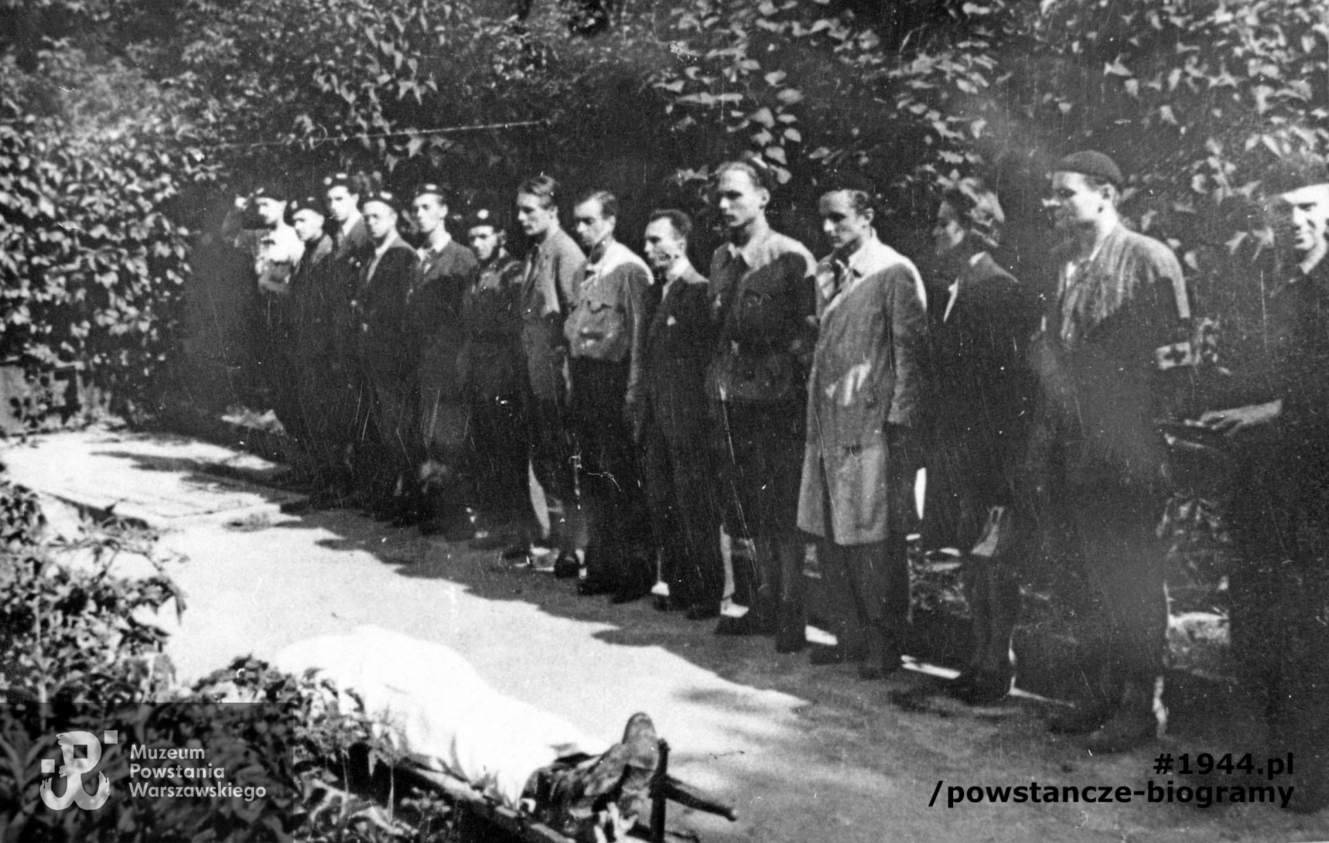 Fotografia z Powstania Warszawskiego, 3 sierpnia 1944 roku - żołnierze dywizjonu "Jeleń" oddają  hołd poległemu ppor. Stanisławowi Jenike "Hańskiemu". Wachm. Jerzy Tyrawski "Tomaszewski" widoczny na zdjęciu ósmy od lewej (i zarazem siódmy z prawej strony). Fot. ze zbiorów Muzeum Powstania Warszawskiego, sygn. MPW-IH/1209