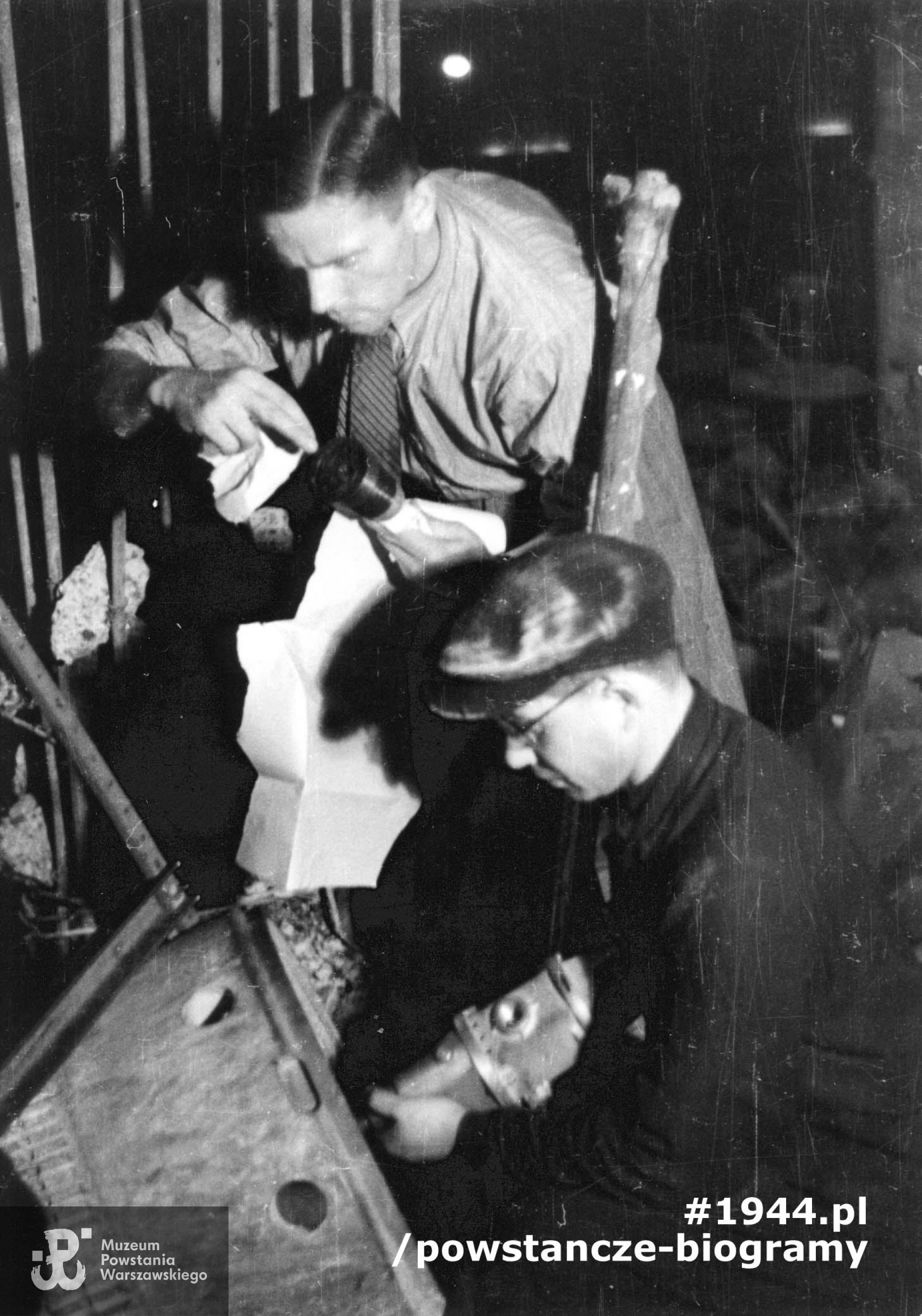 Fotografia z Powstania Warszawskiego. Śródmieście Północne. Pirotechnicy rozbrajający niewybuch pocisku moździerzowego kaliber 600 mm w restauracji "Adria" przy ulicy Moniuszki 10. Na pierwszym planie sierż. pchor. Tadeusz Fabjanowicz "Fabian", w głębi stoi ppor. Stanisław Dutkiewicz "Pillert". Fotografia  autorstwa Eugeniusza Lokajskiego „Broka”, zbiory Fototeki  MPW, sygn.  MPW-IN/381.  Prawa autorskie: MPW