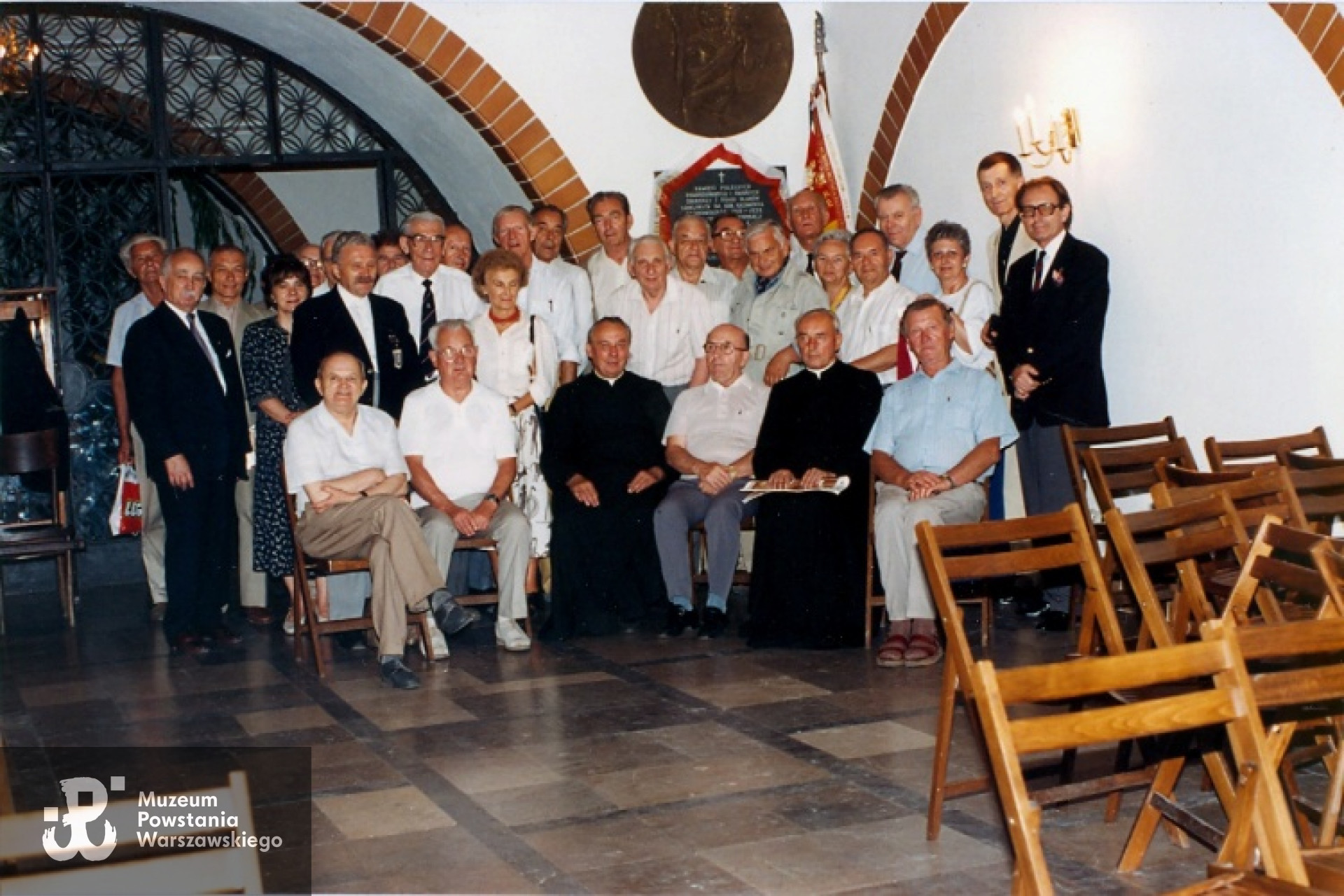 Dionizy Piotr Mazur "Piotrek" wśród Siódmaków z "Jelenia" zgromadzonych w 50 rocznicę Powstania Warszawskiego w podziemiach kościoła pod wezwaniem św. Karola Boromeusza, koło tablicy ku pamięci poległych 7 Pułku Ułanów Lubelskich w czasie wojny 1939-1945