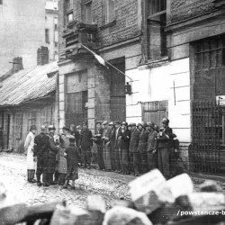 Fotografia z Powstania Warszawskiego,  3 sierpnia 1944. Zbiórka oddziału powstańczego pod kamienicą Pańska 105. Ujęcie od strony ul. Wroniej w kierunku południowo-wschodnim. Po lewej ściana szczytowa domu Pańska 101 i drewniany, parterowy domek Pańska 103. W pierwszym rzędzie pod ścianą ósmy od lewej w kaszkiecie strz. Ferdynand Onufrowicz „Dąb” (identyfikacja dokonana wyłącznie przez rodzinę Poległego, w zbiorach MPW ww. powstaniec nie jest rozpoznany). Autorem zdjęcia jest Stefan Bałuk „Kubuś”.  Fot ze zbiorów Muzeum Powstania Warszawskiego, sygn. MPW-IK/1304