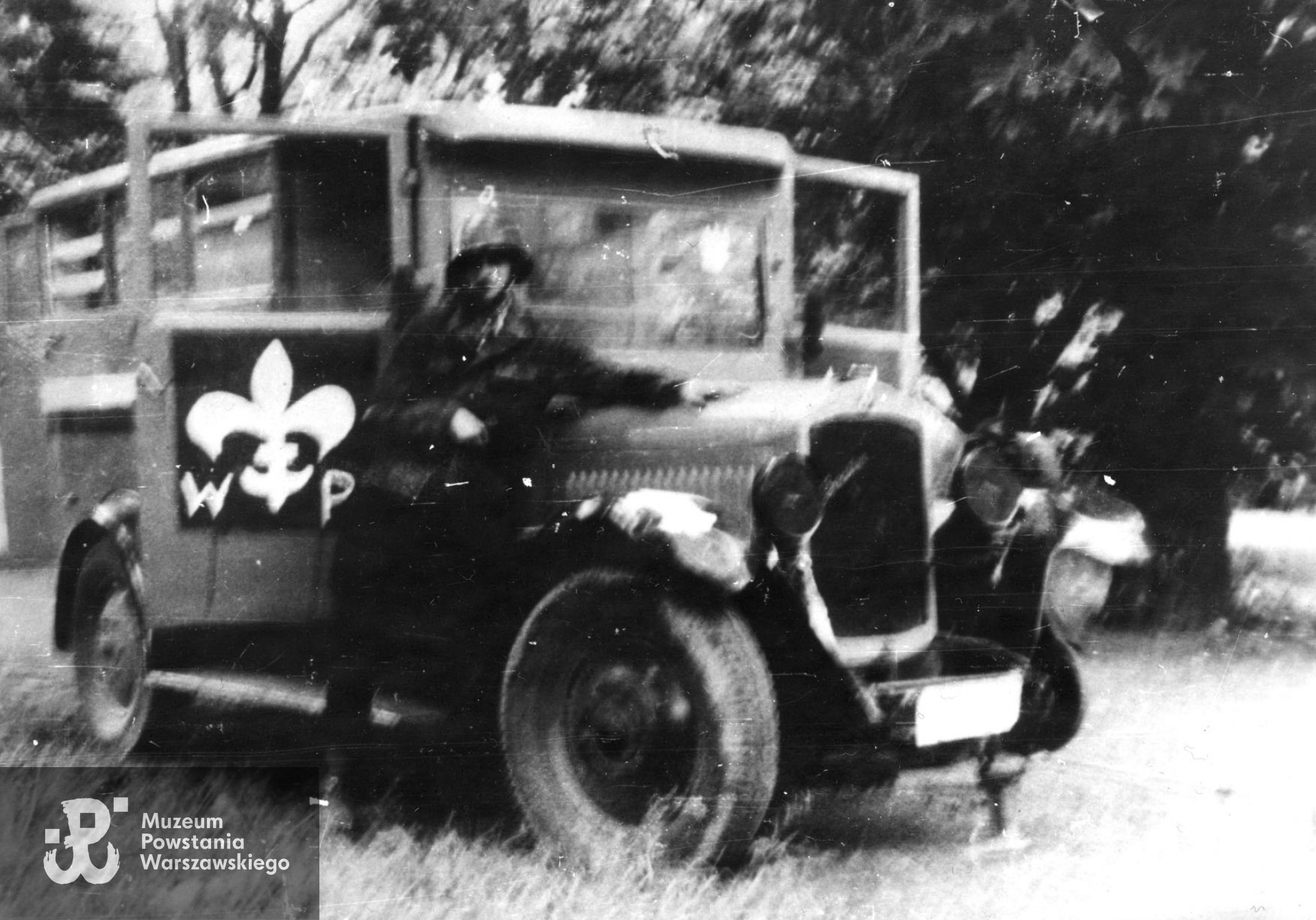 Fotografia z Powstania Warszawskiego. Stare Miasto, Ogród Krasińskich. Ppor. Jan Nestrypke "Borejsza", dowódca 1. plutonu I Kompanii Szturmowej batalionu "Chrobry I", przy samochodzie sanitarnym. Fot.  ze zbiorów Muzeum Powstania Warszawskiego, sygn. MPW-IP/7324