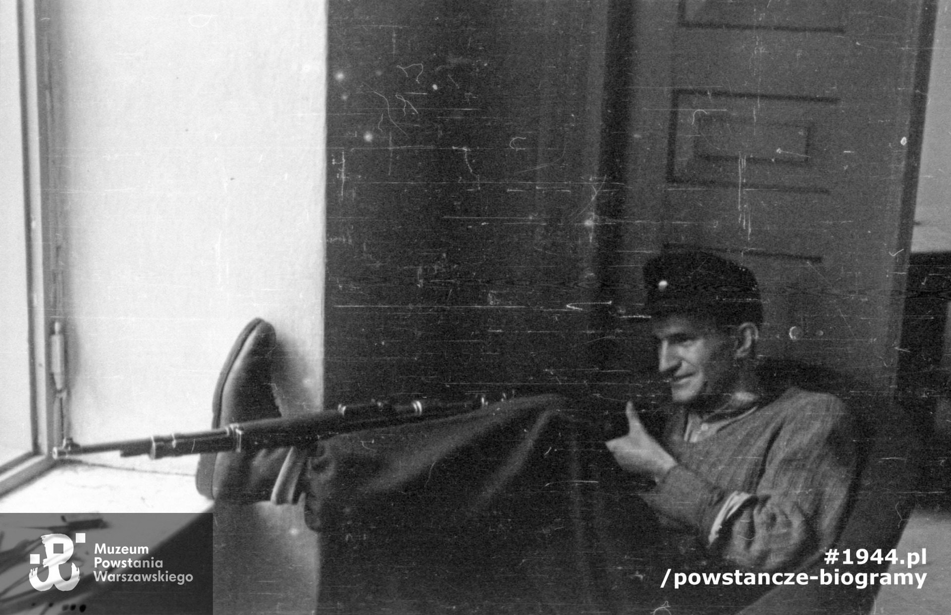 Fotografia z okresu Powstania Warszawskiego, pierwsza połowa sierpnia 1944 r. Stanowisko strzelnicze w domu przy ul. Czackiego 2/4. Z karabinu mierzy kpr. pchor. Jerzy Kokczyński "Boczkowski" z pułku NSZ im. gen. Władysława Sikorskiego. Fot. ze zbiorów Muzeum Powstania Warszawskiego, sygn. MPW-IN/3459