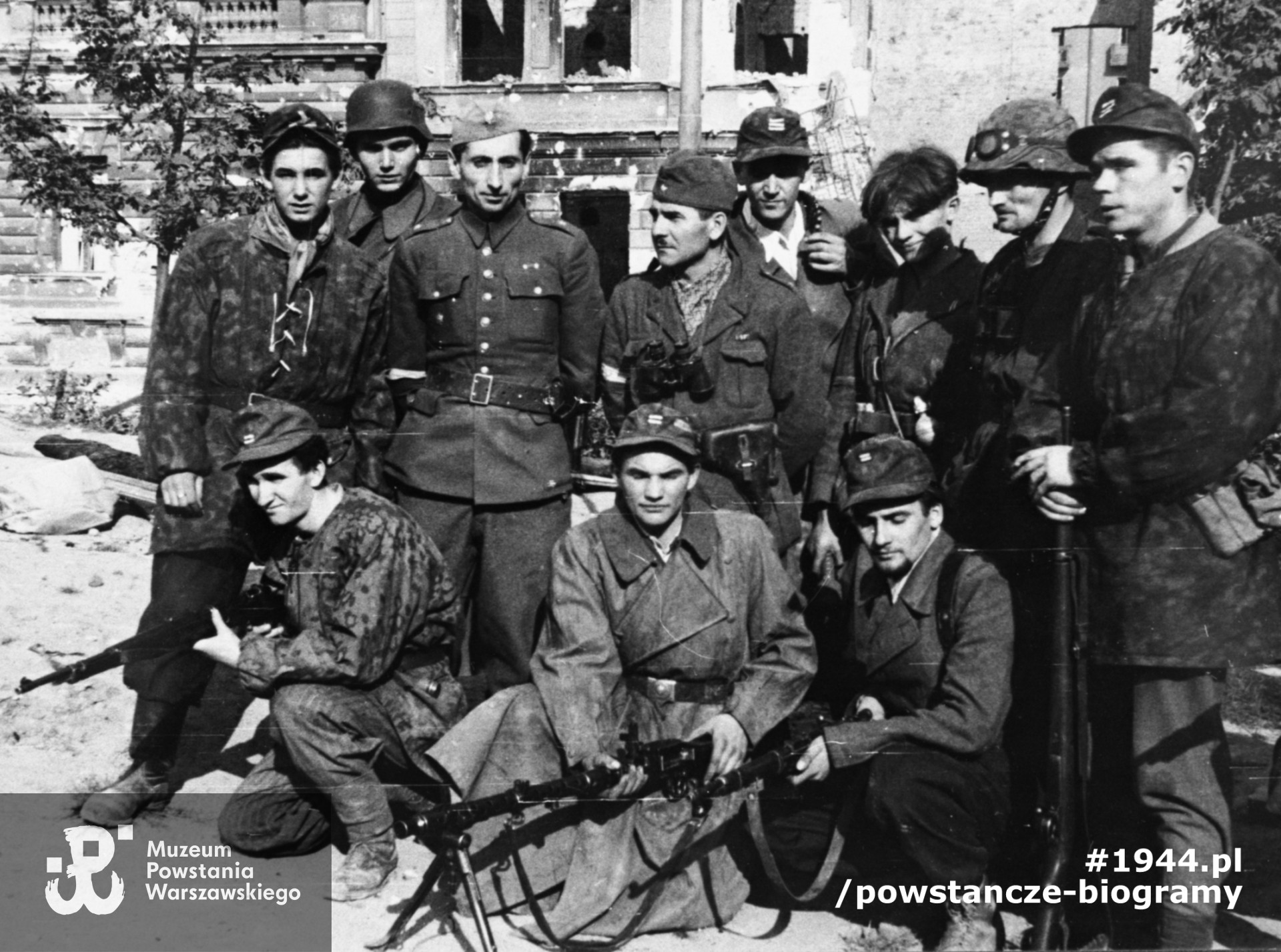 Fotografia z Powstania Warszawskiego, por. Wojciech Pszczółkowski "Kostka" w otoczeniu  żołnierzy OS "Juliusz",  Plac Dąbrowskiego.  Ze zbiorów Muzeum Powstania Warszawskiego, sygn. MPW-IH/4573