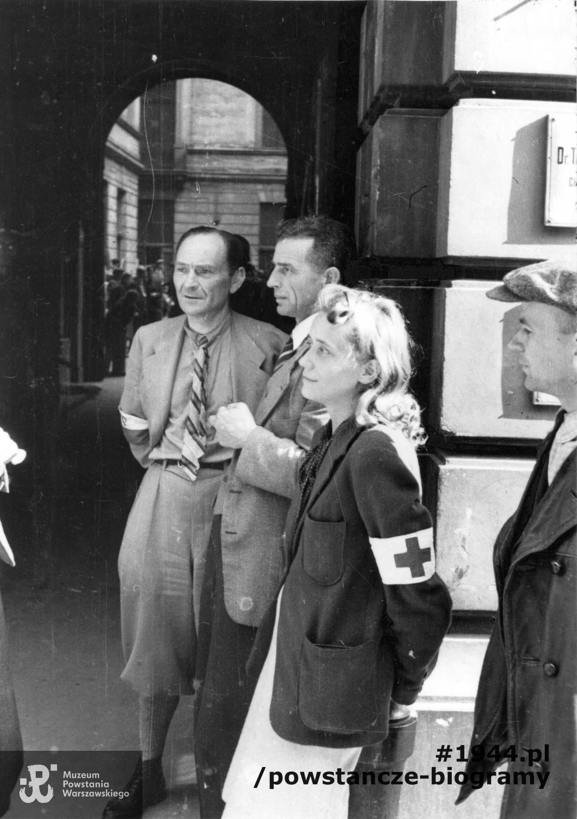 Fotografia z Powstania Warszawskiego. Śródmieście Północne. Grupa powstańców w bramie kamienicy przy ul. Moniuszki 11. Od prawej: NN, sanitariuszka Wanda Regenciak "Alicja", mjr Tadeusz Andrzej Grochowski "Fidelis" oraz prawdopodobnie  kpt. Jan Łączyński "Tadeusz".  Autorem zdjęcia jest Eugeniusz Lokajski "Brok". Fot. ze zbiorów Fototeki MPW, sygn. MPW-IN/200