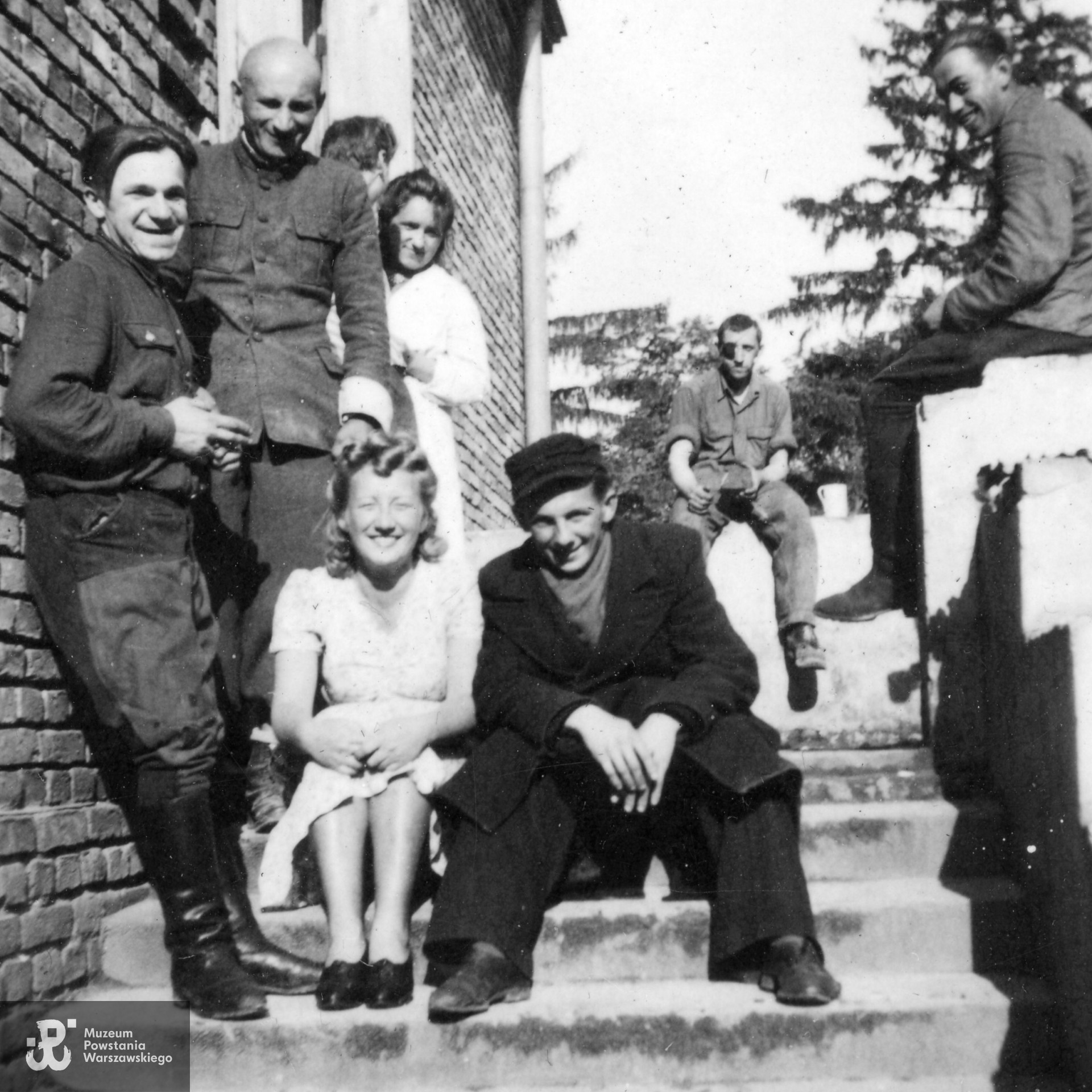 Zdjęcie grupy pacjentów szpitala w Gawartowej Woli. Na schodach siedzą Barbara Gettel i Bernard Sowa ps. Bernard, jej przyszły mąż.  Fot. ze zbiorów rodzinnych, skan udostępnił p. Andrzej Sowa 