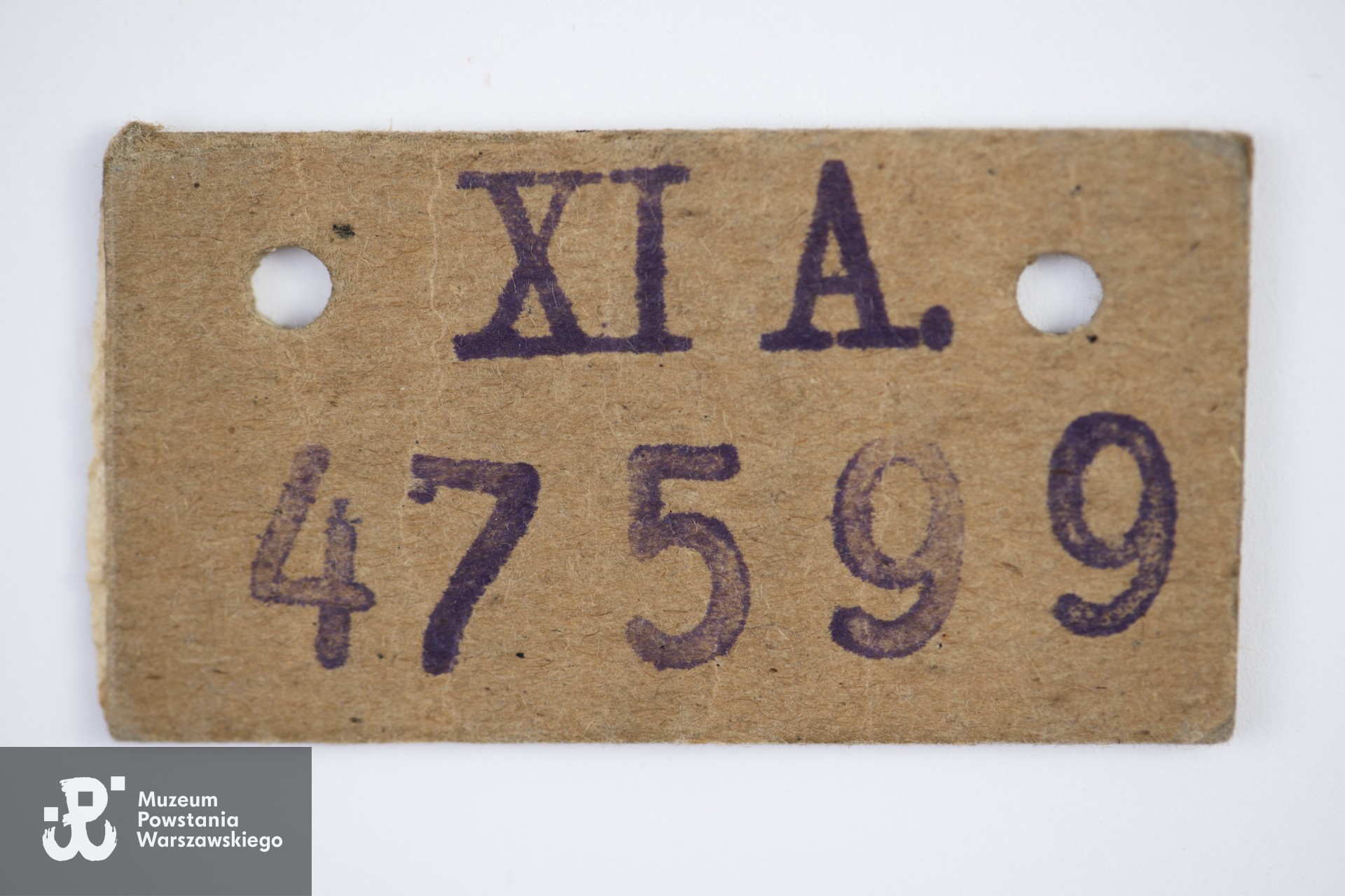 Numer jeniecki identyfikacyjny na tekturce należący do Adama Jerzego Sygalta (Stalag XI-A Altengrabow, numer: 47 599). Ze zbiorów Muzeum Powstania Warszawskiego, sygn. P/9897, dar p. Ewy Sygalt-Synowieckiej i p. Mariusza Synowieckiego