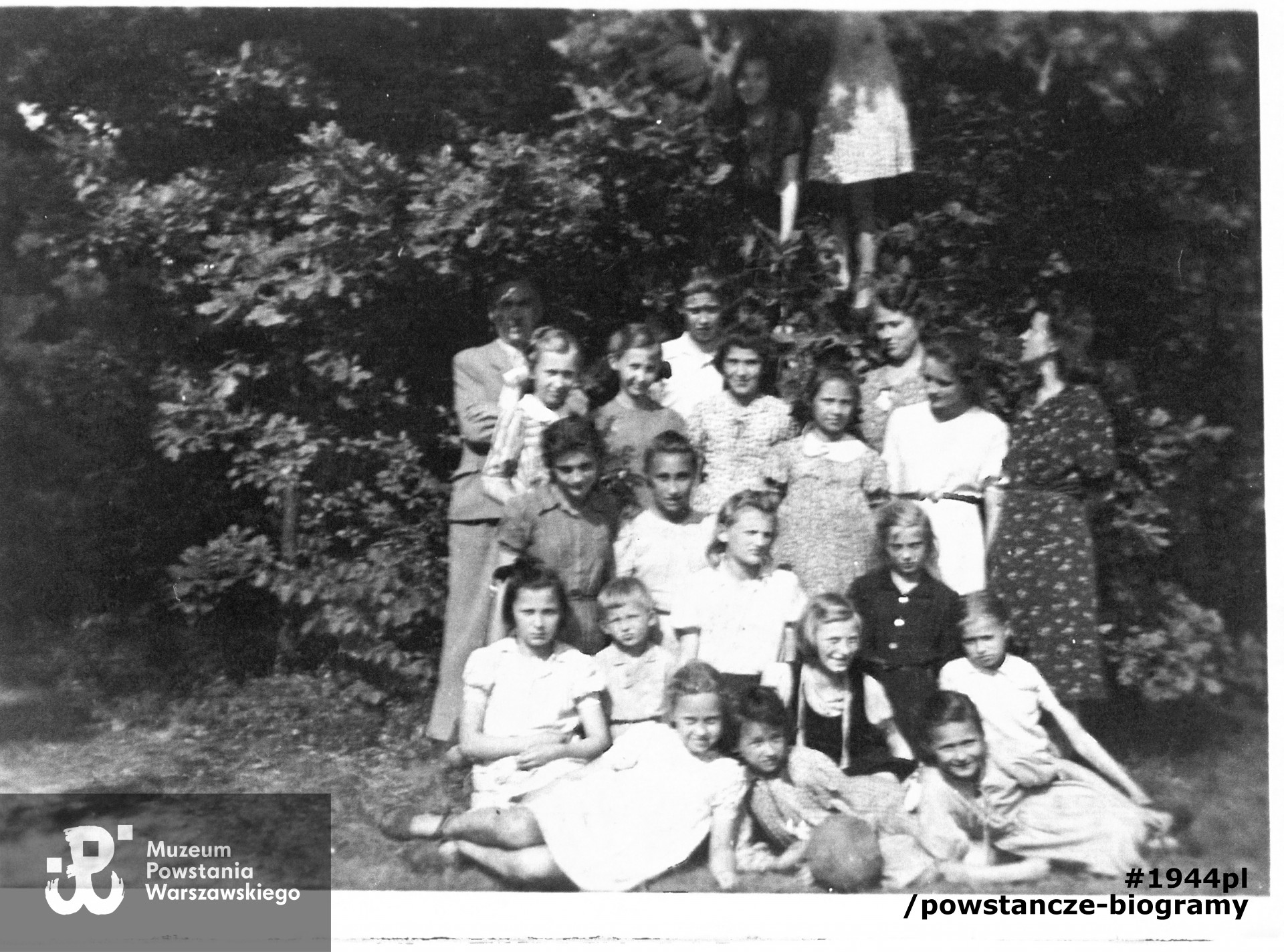 Fotografia  wykonana ok. 1942 roku,  przedstawiająca harcerski z trzech zastępów 100. WŻDH Hufca "Wola" podczas pobytu w Leśniczówce w Izabelinie.  Widoczne na zdjęciu są m. in. po prawej drużynowa Janina Górnicka, Janina Cybulska - Baj "Nulka", z lewej (poniżej mężczyzny i dziewczynki)  Krystyna Rafalska "Stokrotka",  obok dwie zastępowe: Teresa Kerner i  Ada (Adrianna) Wodnicka, która poległa  wraz z koleżankami zamordowana 5 sierpnia 1944 podczas pacyfikacji szpitala św. Łazarza na Woli przez oddziały niemieckie. Skan z fotokopii, zbiory MPW, V-611, dar p. Krystyny Kodymowskiej z d. Rafalskiej ps. Stokrotka