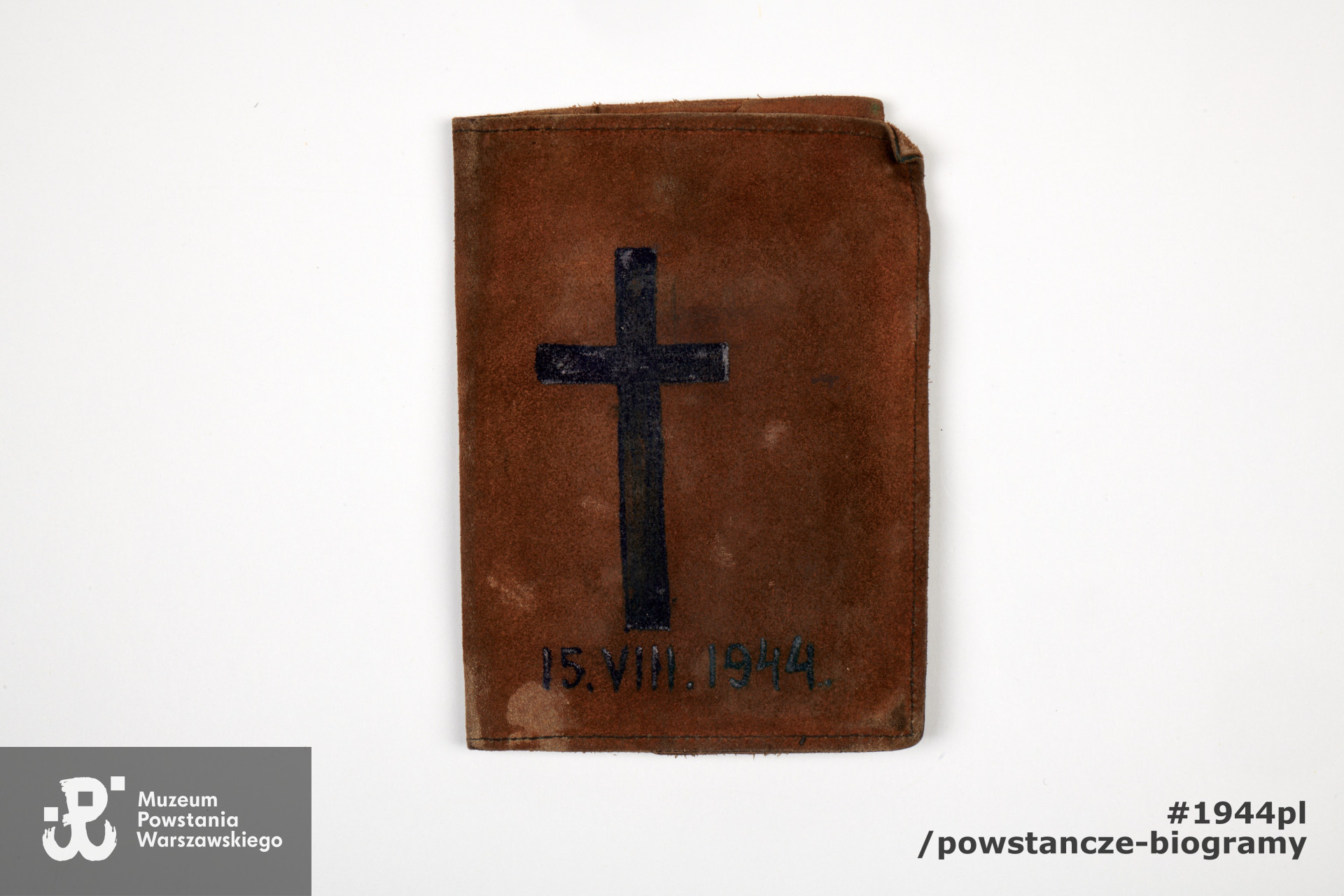 Portfel zamszowy. Na portfelu narysowany (ołówkiem i prawdopodobnie atramentem) krzyż i data: "15.VIII.1944". Ze zbiorów Muzeum Powstania Warszawskiego, sygn. P/5401