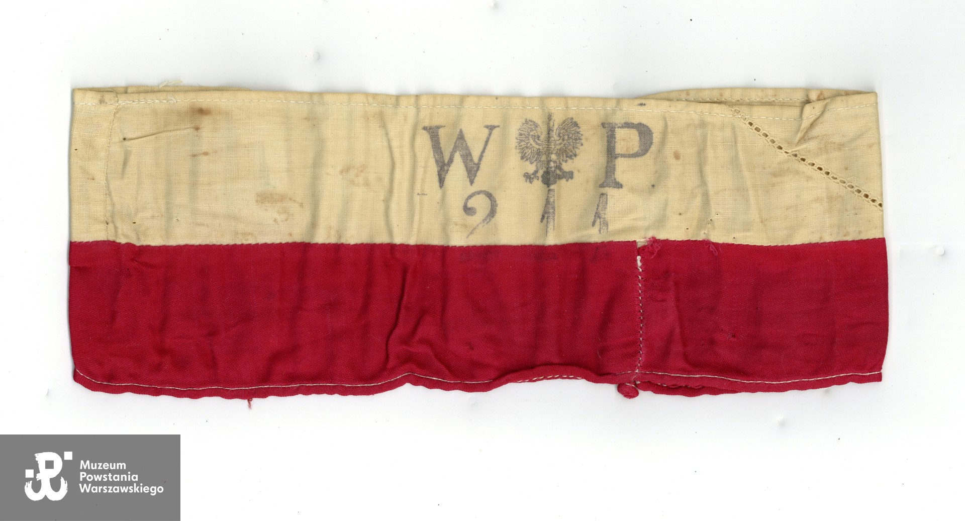 Należąca do Lidii Zwierzchowskiej "Marzeny" opaska biało-czerwona. Ze zbiorów Muzeum Powstania Warszawskiego, przedmiot przekazany przez córkę p. Lidii Zwierzchowskiej  (Konecki), p. Ewę Nowakowski, sygn. P/10128, numer inwentarzowy: MPW-M/3846