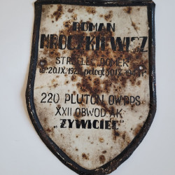 Tabliczka nagrobna Romana Mroczkiewicza znaleziona na polu  ornym polu  w miejscowości Pociecha, gmina Izabelin. Obecnie w zbiorach Muzeum Powstania Warszawskiego.
