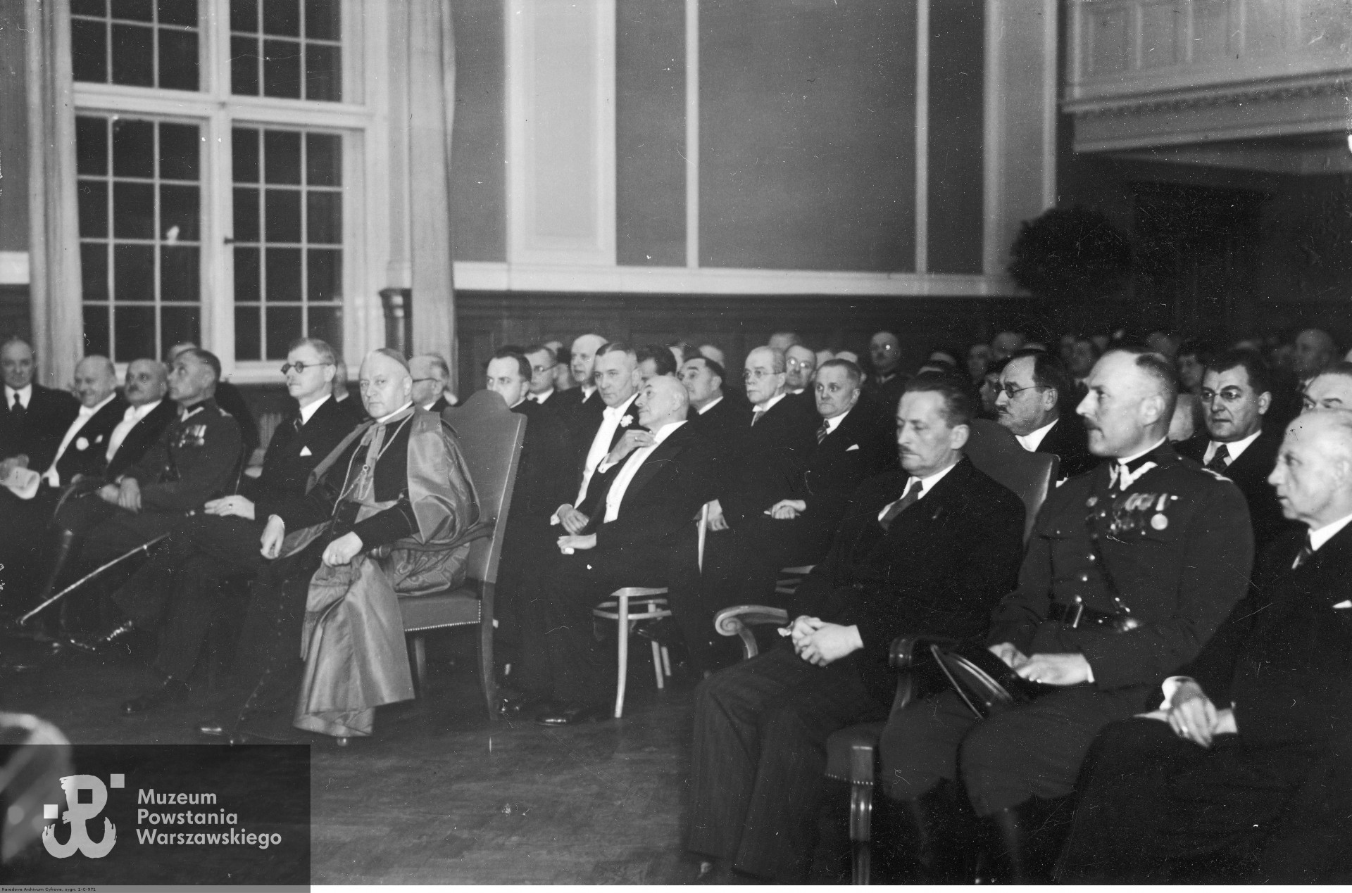 Akademia z okazji 50-lecia pisma medycznego "Nowiny Lekarskie" w Małej Auli Uniwersytetu Poznańskiego, 27 listopada 1938 r. W pierwszym rzędzie siedzą od prawej: starosta krajowy poznański Ludwik Begale, pułkownik Alfred Chełmicki, wojewoda poznański Artur Maruszewski, kardynał August Hlond, rektor Uniwersytetu Poznańskiego, prof. Antoni Peretiatkowicz, pułkownik Teofil Kucharski. Fot. ze zbiorów Narodowego Archiwum Cyfrowego - Koncern Ilustrowany Kurier Codzienny - Archiwum Ilustracji, www.audiovis.nac.gov.pl