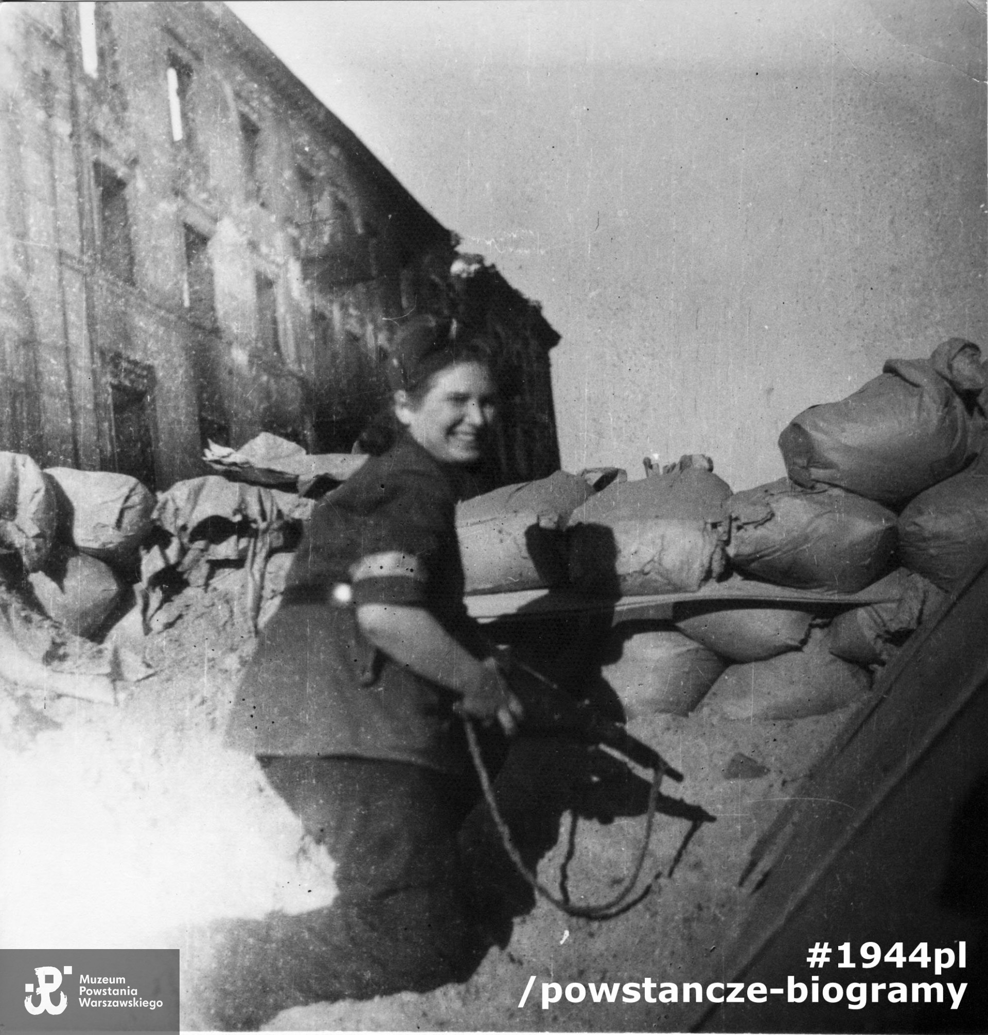 Sanitariuszka Jadwiga Włodarska "Jadzia" z 3 plutonu kompanii szturmowej batalionu "Kiliński" na barykadzie pod kamienicą Grzybowska 6. Ujęcie w kierunku północno-wschodnim. Fotografia ze zbiorów Muzeum Powstania Warszawskiego sygnatura MPW-IP/2387