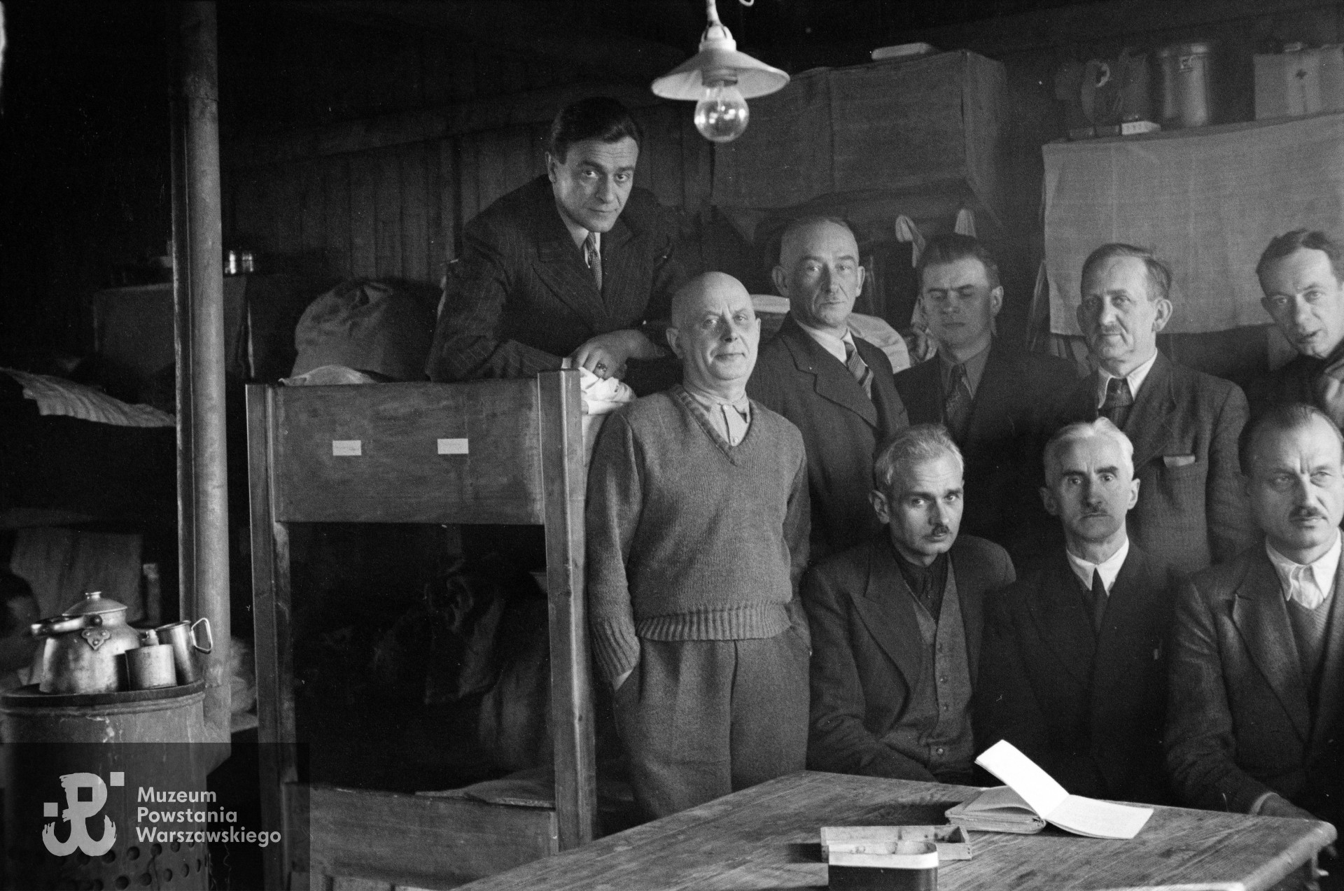 Fotografia z Polskiego Szpitala Wojskowego w saksońskim Zeithain. Lekarze w baraku 14. Na pryczy dr Zdzisław Januszewski. Stoją od lewej: por. Jan Sawczak „Knihinicki”, płk dr Leon Strehl „Feliks”, NN, dr Mieczysław Zapolski, dr Marian Mroczkowski. Siedzą: dr Stanisław Manczarski , mjr dr dr Tadeusz Kawecki „Lwowicz”, mjr dr Jan Durko „Dunin”. Autorem zdjęcia jest Czesław Gerwel „Orłoś”. Fot. ze zbiorów Muzeum Powstania Warszawskiego, sygn. MPW-IN/3793