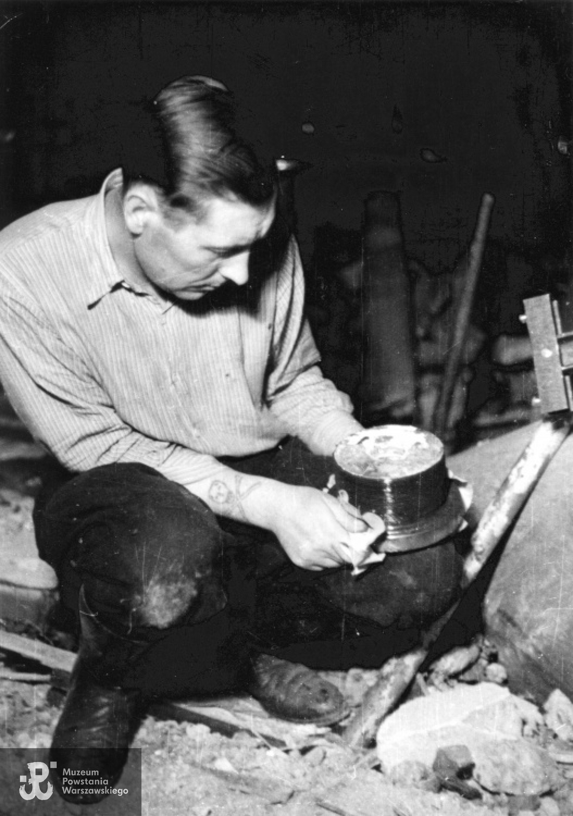 18 sierpnia 1944 r. Śródmieście Północne. St. sierż. Józef Gorzowski "Szczepcio" trzymający zapalnik niewybuchu pocisku w restauracji "Adria" przy ulicy Moniuszki 10. Fotografia  autorstwa Eugeniusza Lokajskiego „Broka”, zbiory Fototeki  MPW, sygn.  MPW-IN/382.  Prawa autorskie: MPW