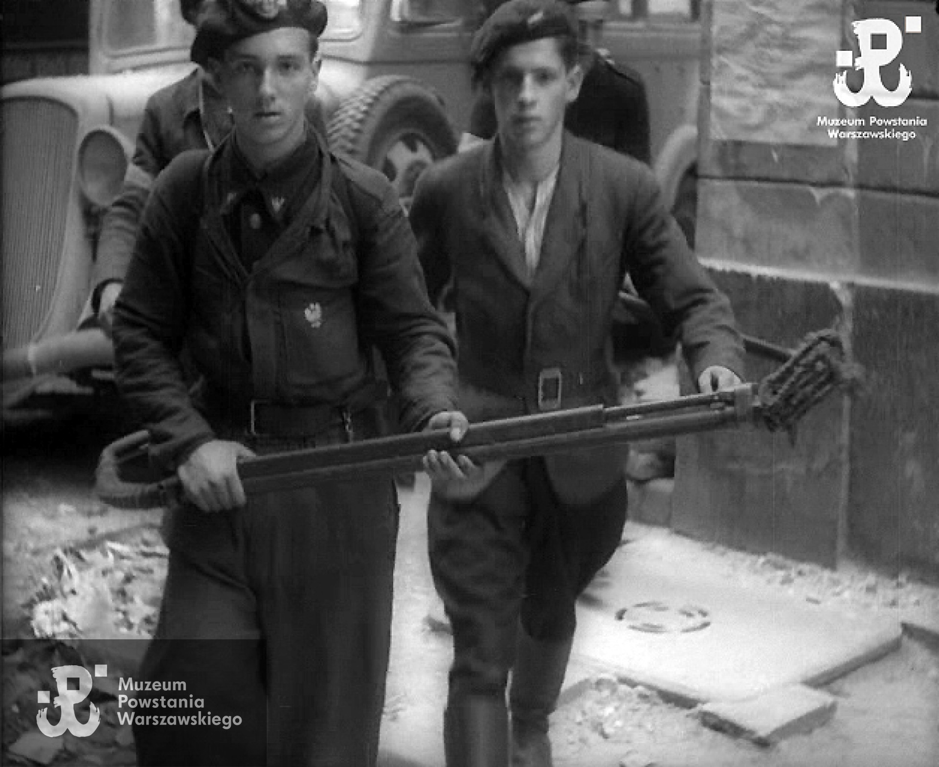 Kadr w powstańczej kroniki - Wojciech Luterek „Roman” z prawej strony, bez miotacza płomieni. Fot. MPW