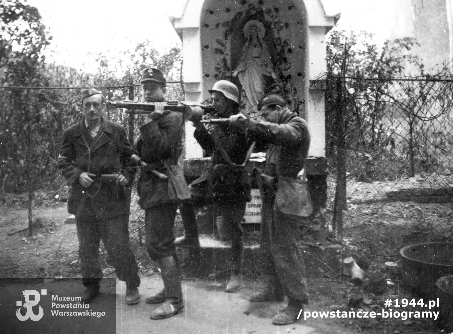 Fotografia z Powstania Warszawskiego. Grupa żołnierzy oddziału "Rygla" pozująca do zdjęcia z bronią. Od lewej:  NN, obok kpr. pchor. Janusz Sawicki "Zabawa" i  opierający o jego ramię rkm strz. Antoni Bukraba "Żeglarz", czwarty żołnierz nierozpoznany (NN). Ze zbiorów Muzeum Powstania Warszawskiego, sygn. MPW-IP/3797