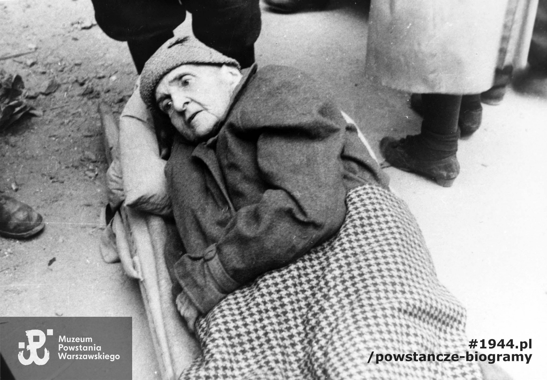 Fotografia wykonana podczas Powstania Warszawskiego. Śródmieście Północne. Ewakuacja Marii Rodziewiczówny. Autorem zdjęcia jest Antoni Bohdziewicz. Fot. ze zbiorów Muzeum Powstania Warszawskiego, sygn. MPW-IH/810