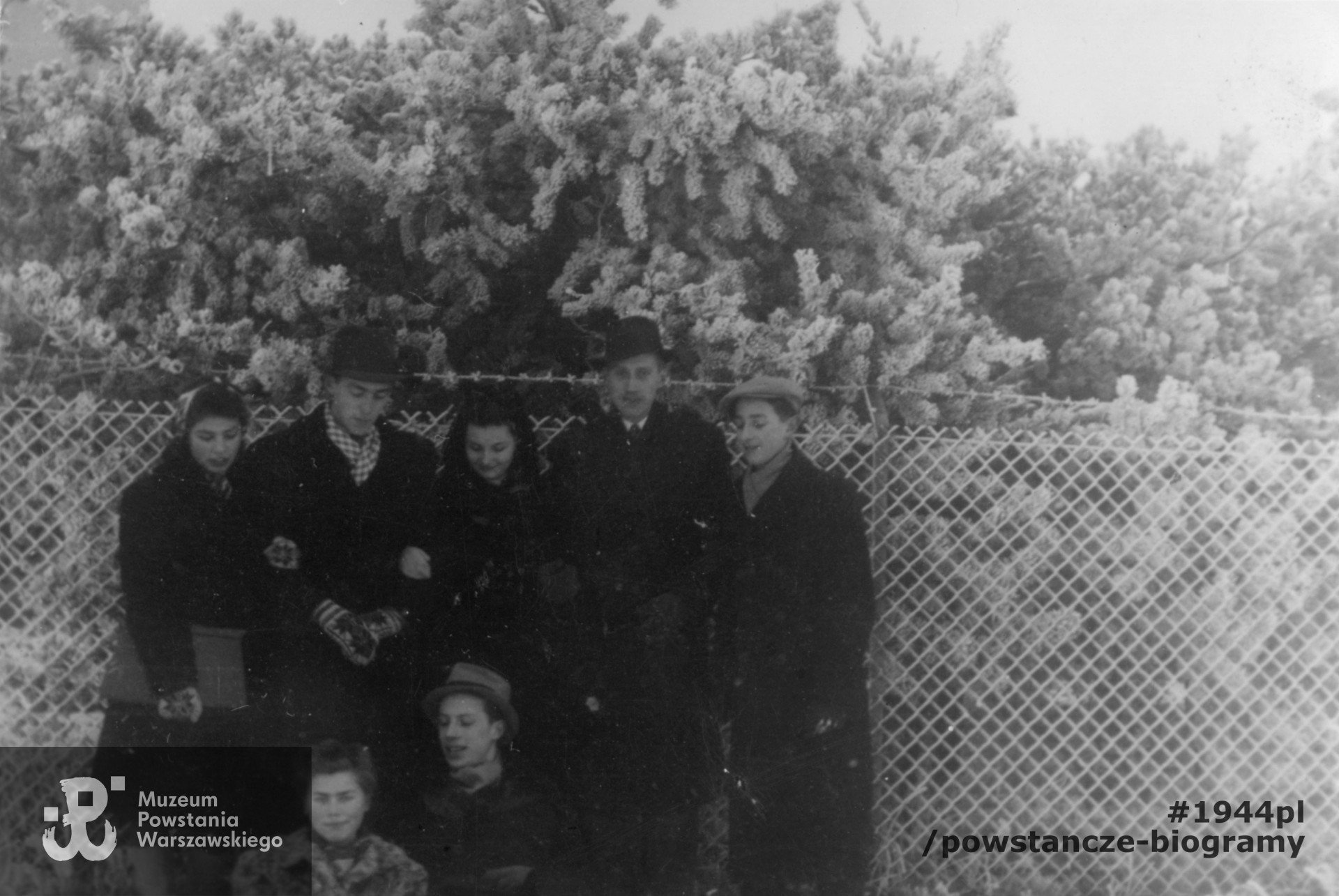 Fotografia z okresu okupacji niemieckiej. Warszawa. Grupa znajomych podczas zimowego spaceru. Od lewej stoją: Anna Kanicka, Olgierd Budrewicz "Konrad", Hanna Kamler "Kama", Kazimierz Skrobik „Koń”, Wiktor Natanson „Humięcki”, u dołu siedzą: Alicja Natanson "Pies"  i Mieczysław Skrobik "Zawada". Fot. ze zbiorów Muzeum Powstania Warszawskiego, sygn. MPW-IP/6321/182,  kolekcja Olgierda Budrewicza pseud. "Konrad".