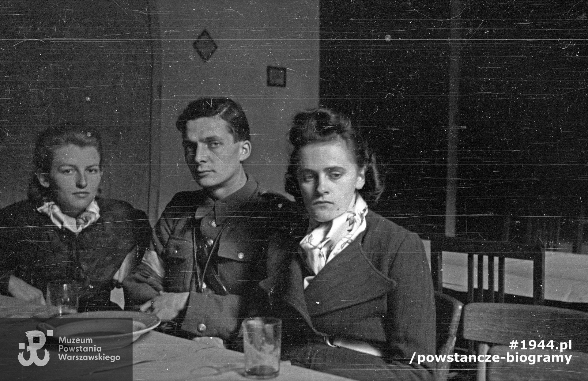 Powstanie Warszawskie, wrzesień 1944 r. Posiłek powstańców z kompanii "Anna” batalionu "Gustaw” w kwaterze przy ulicy Jasnej 19. Przy stole siedzą od lewej: Danuta Magreczyńska "Danka”, por. Wojciech Sarnecki "Wojtek”, Janina Sanecka "Roma”. Autorem zdjęcia jest Wiesław Chrzanowski. Ze zbiorów Muzeum Powstania Warszawskiego, sygn. MPW-IN/3324