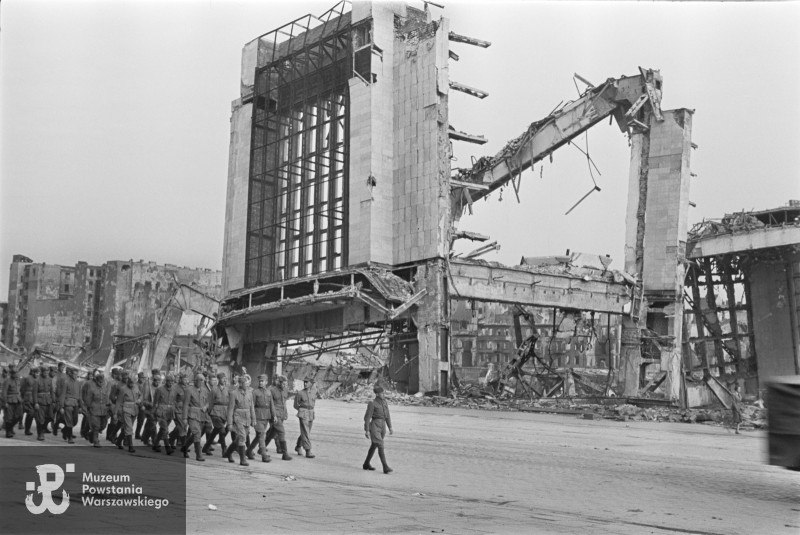 Żołnierze Wojska Polskiego idą Alejami Jerozolimskimi w kierunku wschodnim. W tle pozostałości Dworca Głównego. Zima lub wczesna wiosna 1945 roku. Fot. Sylwester Braun „Kris”/MPW