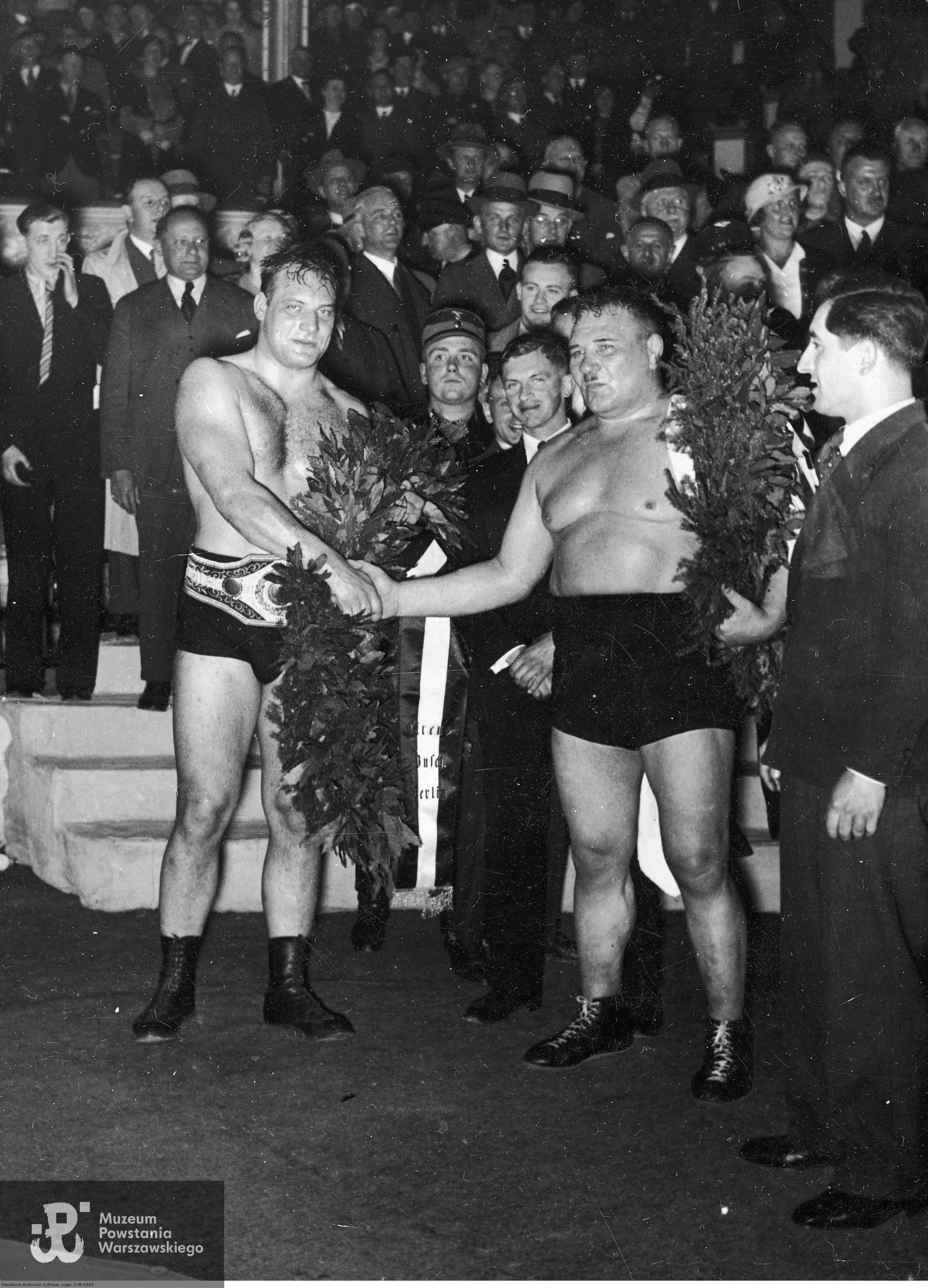  Aleksander Garkowienko (z prawej) gratuluje zwycięstwa Hansowi Schwarzowi (ze złotym pasem), maj 1934 r., fotografia ze zbiorów Narodowego Archiwum Cyfrowego sygnatura 1-M-1923