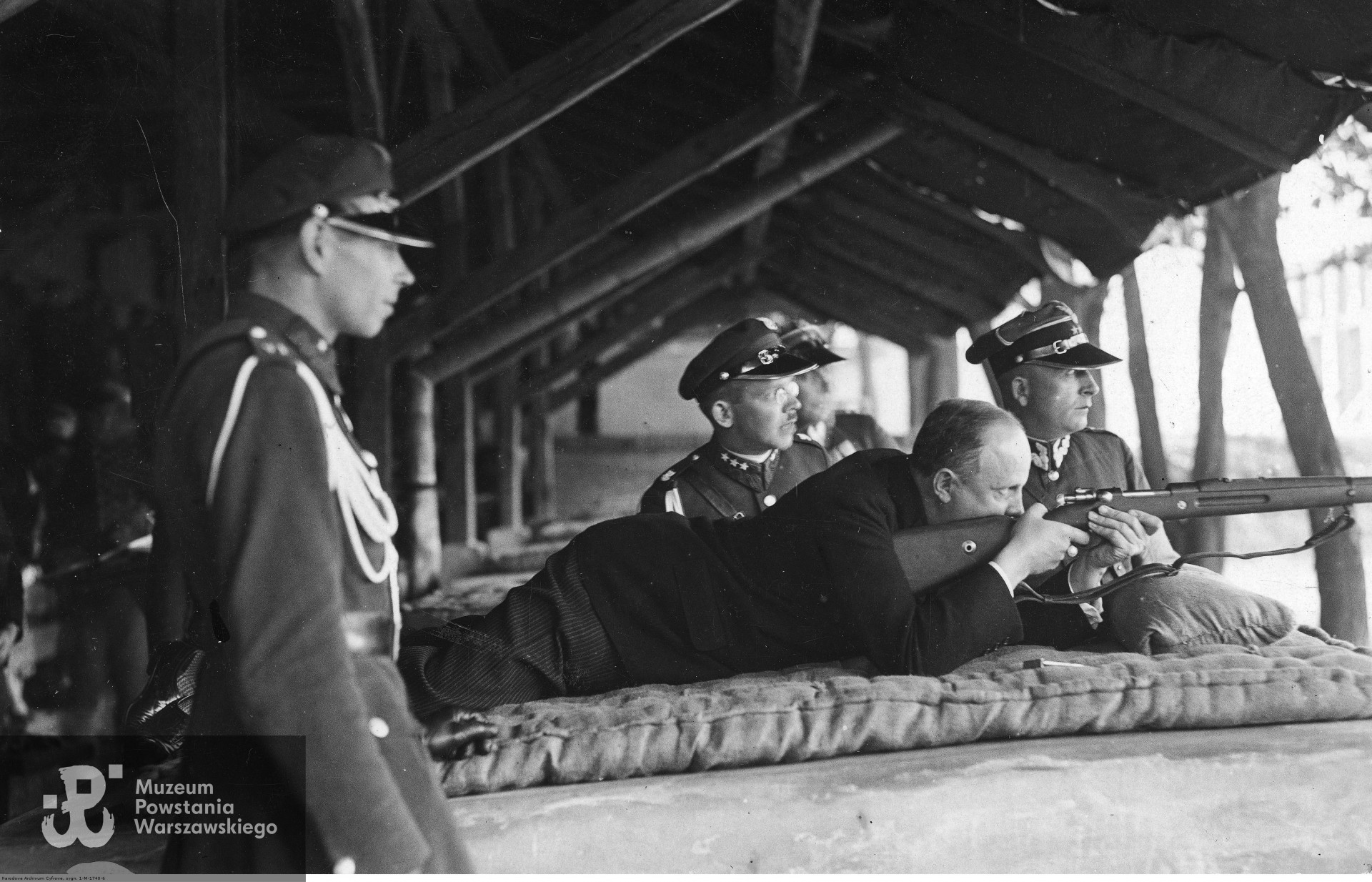 Wojewoda lwowski Józef Rożniecki (na leżąco) oddaje strzał honorowy z karabinka wojskowego wz. 29 na otwarciu Międzynarodowych Zawodów Strzeleckich, Myśliwskich i Łucznych w otoczeniu innych strzelców. Zdjęcie ze zbiorów Narodowego Archiwum Cyfrowego sygnatura 1-M-1740-6