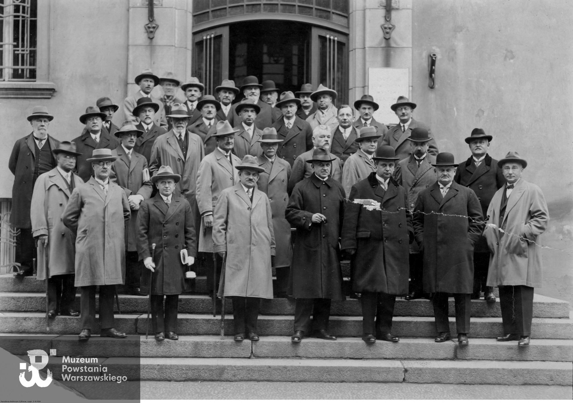 Rada Główna Powszechnej Wystawy Krajowej w Poznaniu; członkowie rady. Widoczni m.in.: dyrektor Stanisław Wachowiak (3. z lewej w pierwszym rzędzie), minister Karol Bertoni (4. z lewej w pierwszym rzędzie), wojewoda Piotr Dunin-Borkowski (3. z prawej w pierwszym rzędzie), starosta Ludwik Begalle (2. z prawej w pierwszym rzędzie) oraz senator Witold Hedinger (1. z lewej w drugim rzędzie). Zdjęcie ze zbiorów Narodowego Archiwum Cyfrowego sygnatura 1-G-916